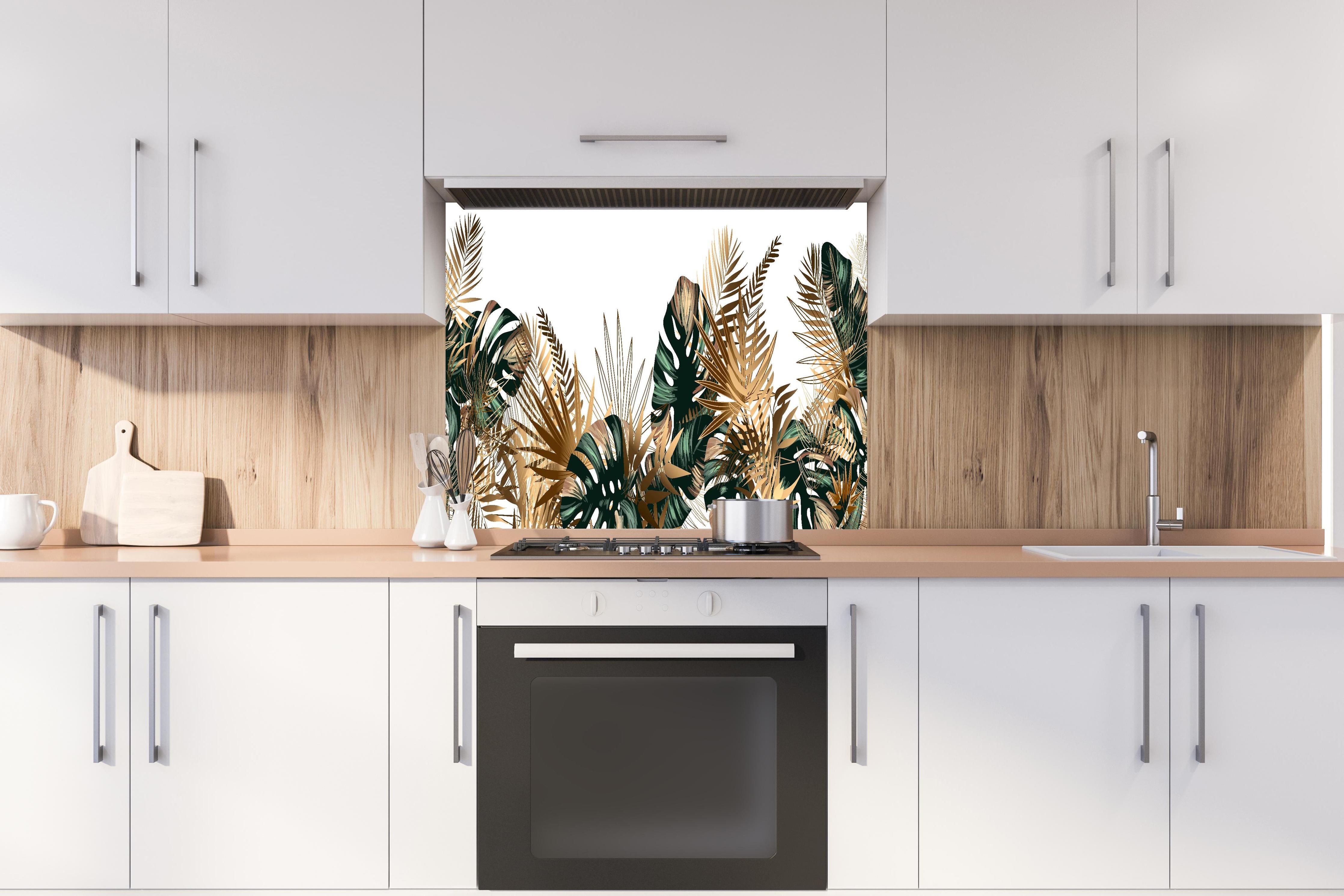 Spritzschutz - Exotisches Gold-Grün Palmenblatt Muster hinter einem Cerankochfeld zwischen Holz-Kochutensilien