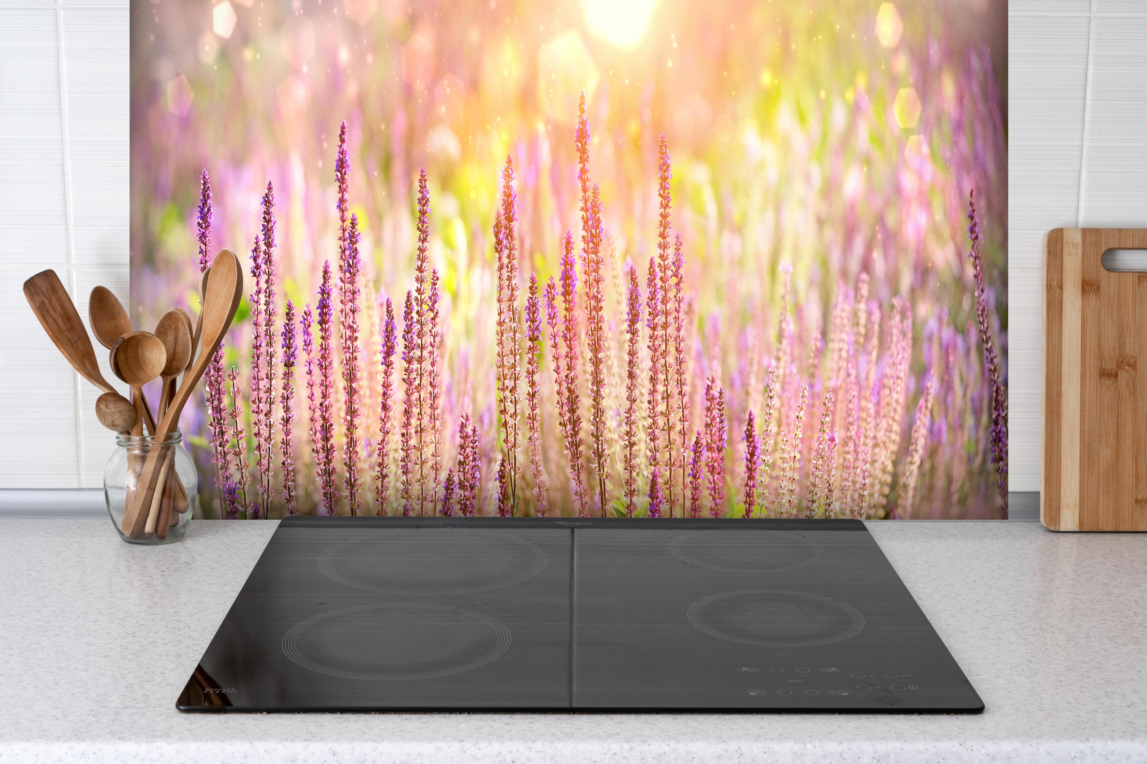 Spritzschutz - Farbenfrohe Blüten der Ziersalbei-Pflanzen hinter einem Cerankochfeld zwischen Holz-Kochutensilien