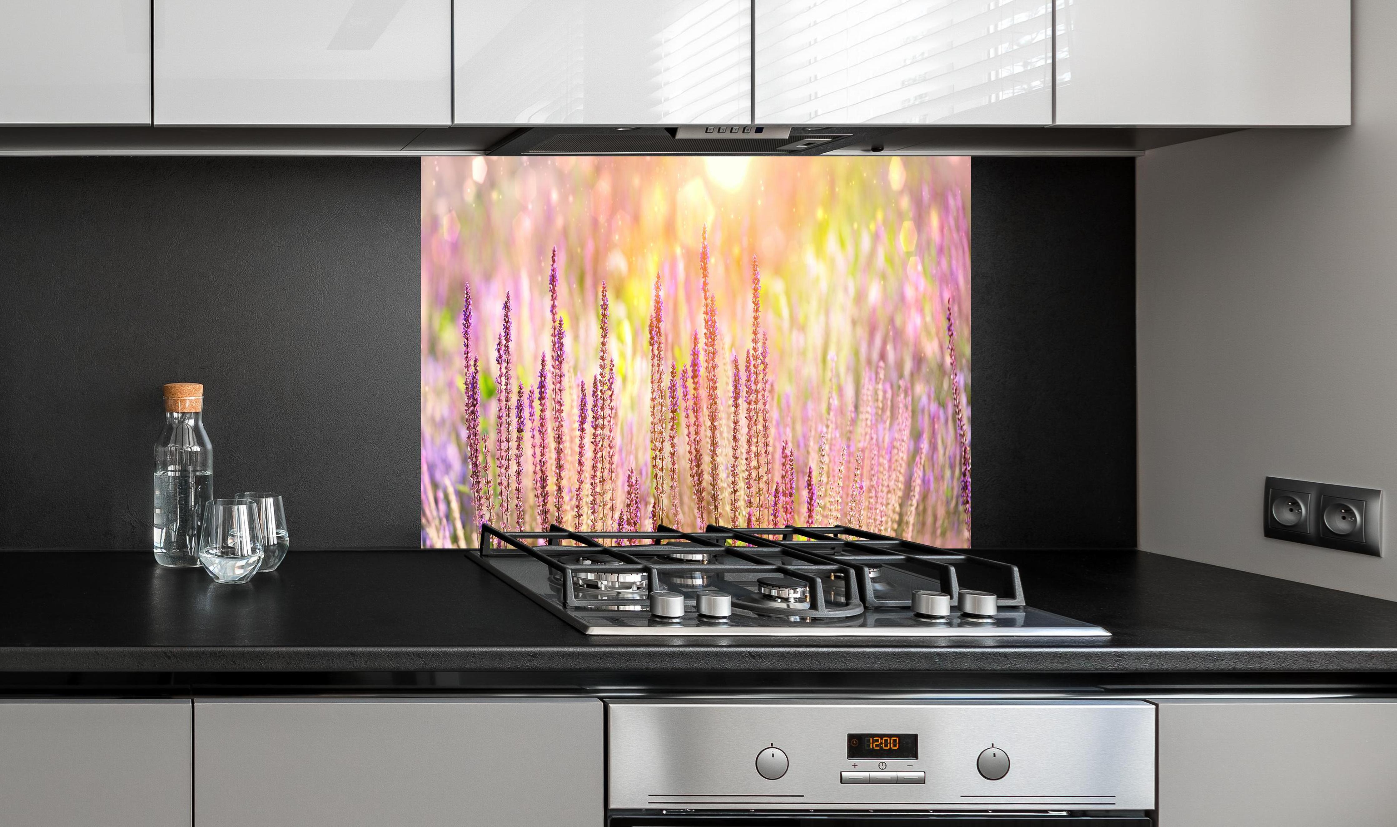 Spritzschutz - Farbenfrohe Blüten der Ziersalbei-Pflanzen hinter einem Cerankochfeld zwischen Holz-Kochutensilien