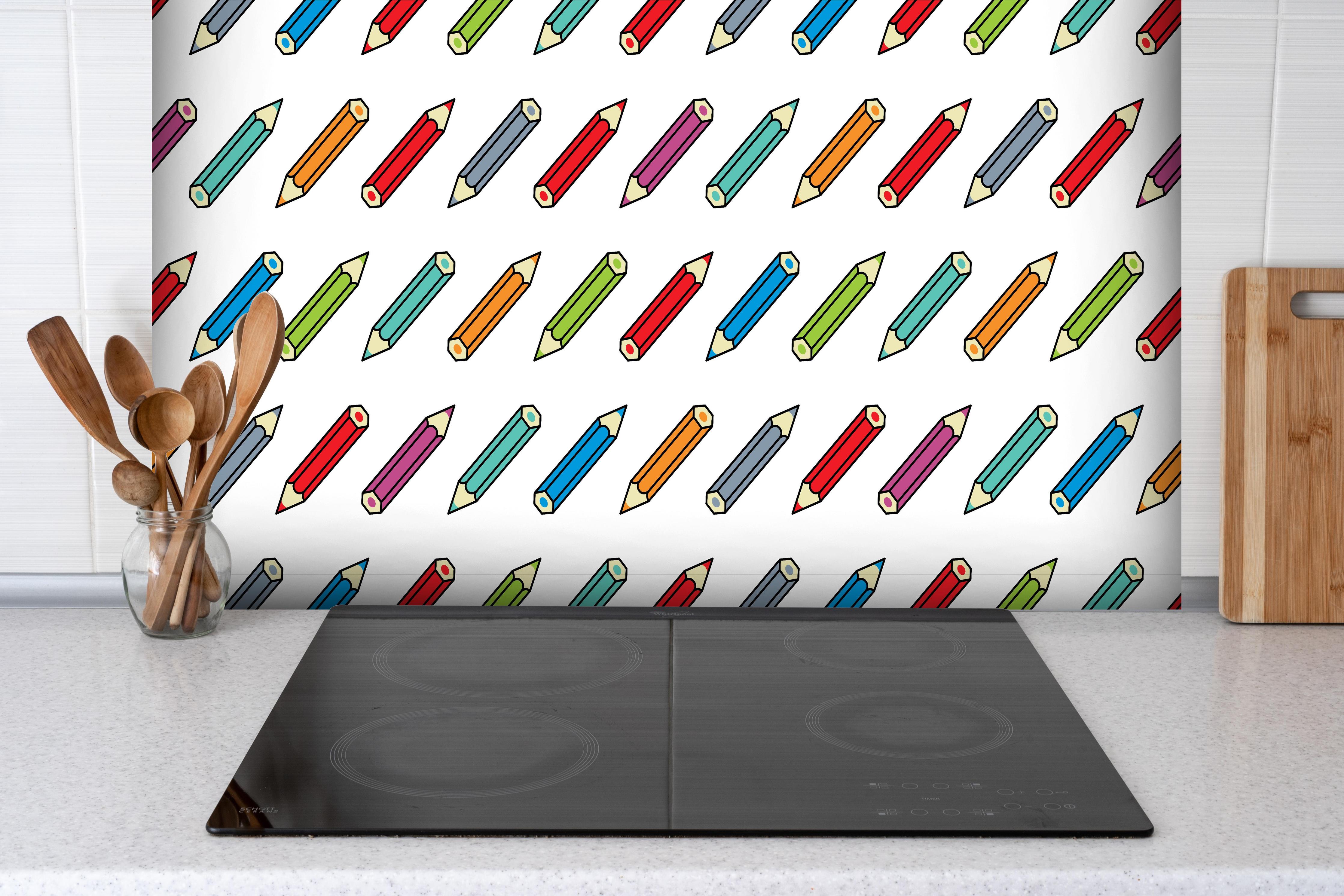 Spritzschutz - Farbenfrohe Schreibwaren Grafikmuster hinter einem Cerankochfeld zwischen Holz-Kochutensilien