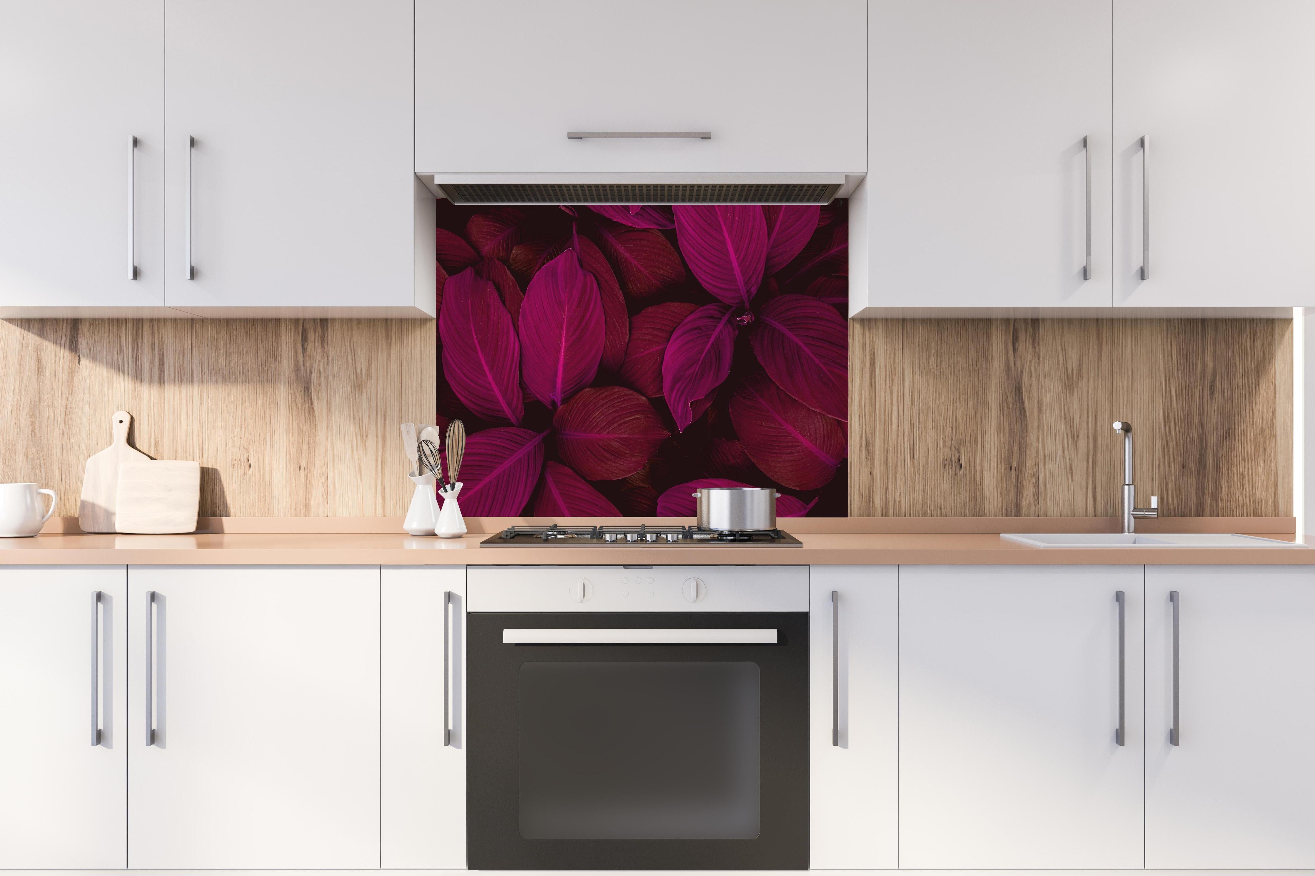 Spritzschutz - Farbenfrohe Spathiphyllum Blatttextur hinter einem Cerankochfeld zwischen Holz-Kochutensilien