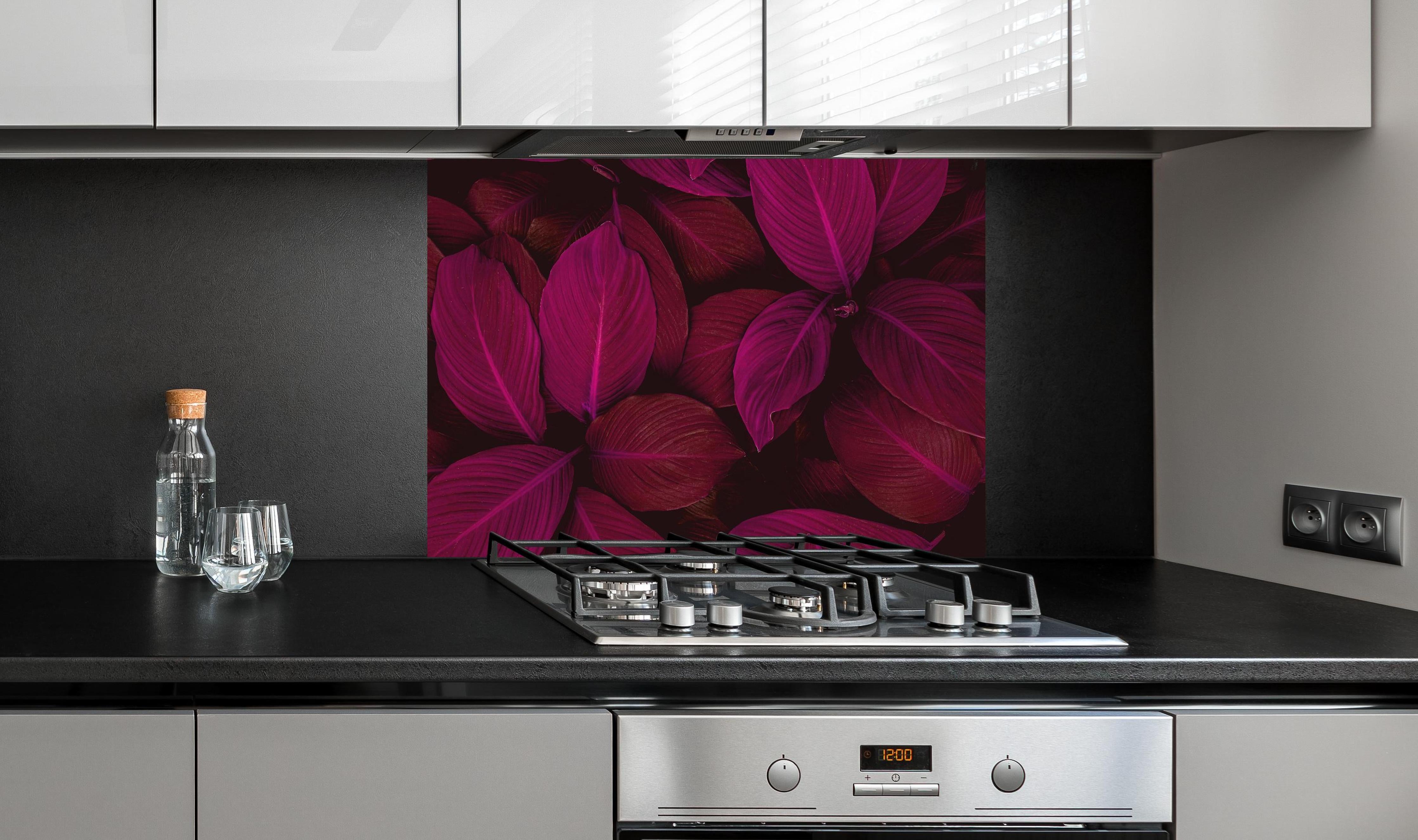 Spritzschutz - Farbenfrohe Spathiphyllum Blatttextur hinter einem Cerankochfeld zwischen Holz-Kochutensilien