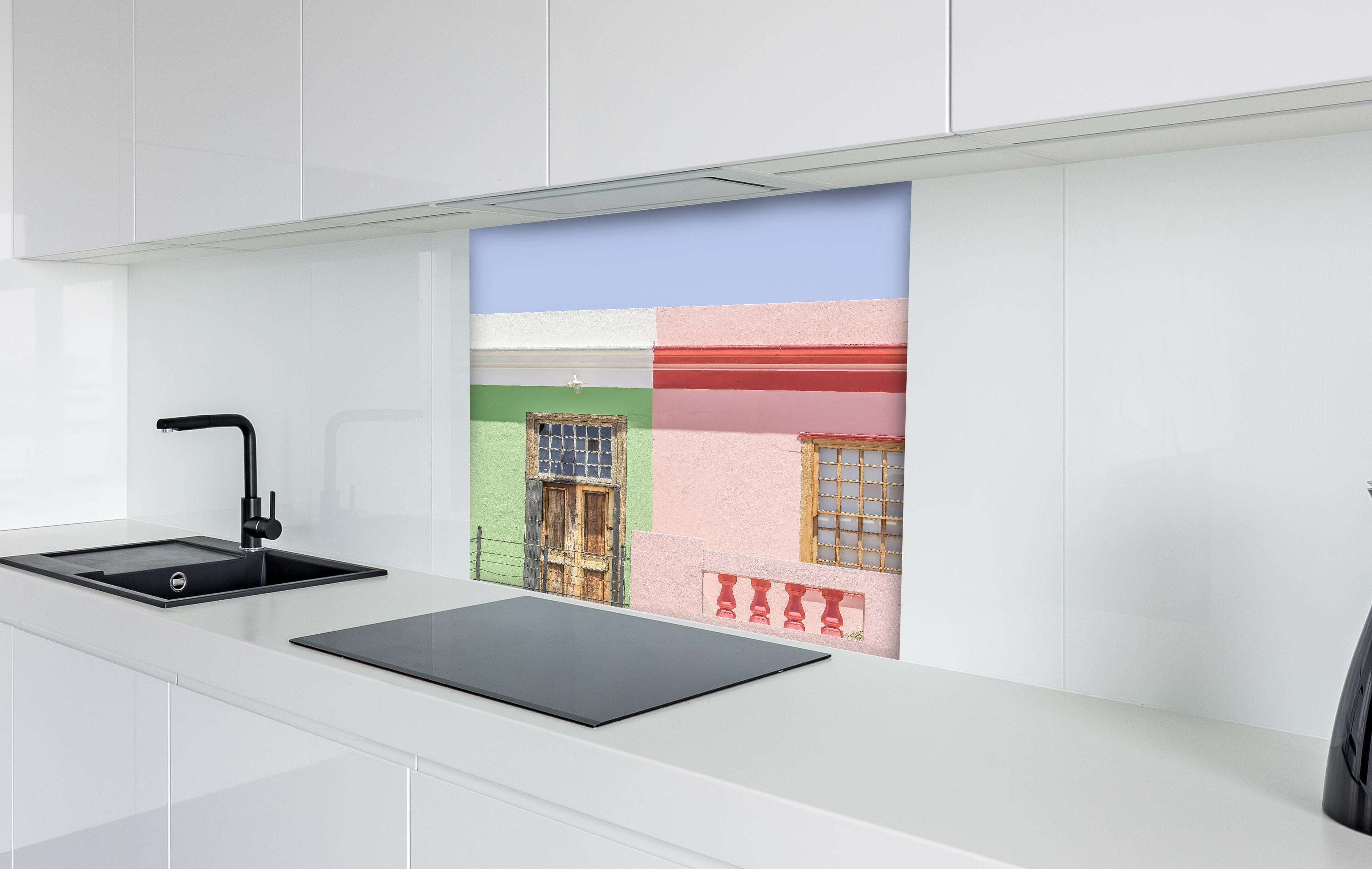 Spritzschutz - Farbenfrohe Stadthaus Fassaden im Sonnenlicht hinter einem Cerankochfeld zwischen Holz-Kochutensilien