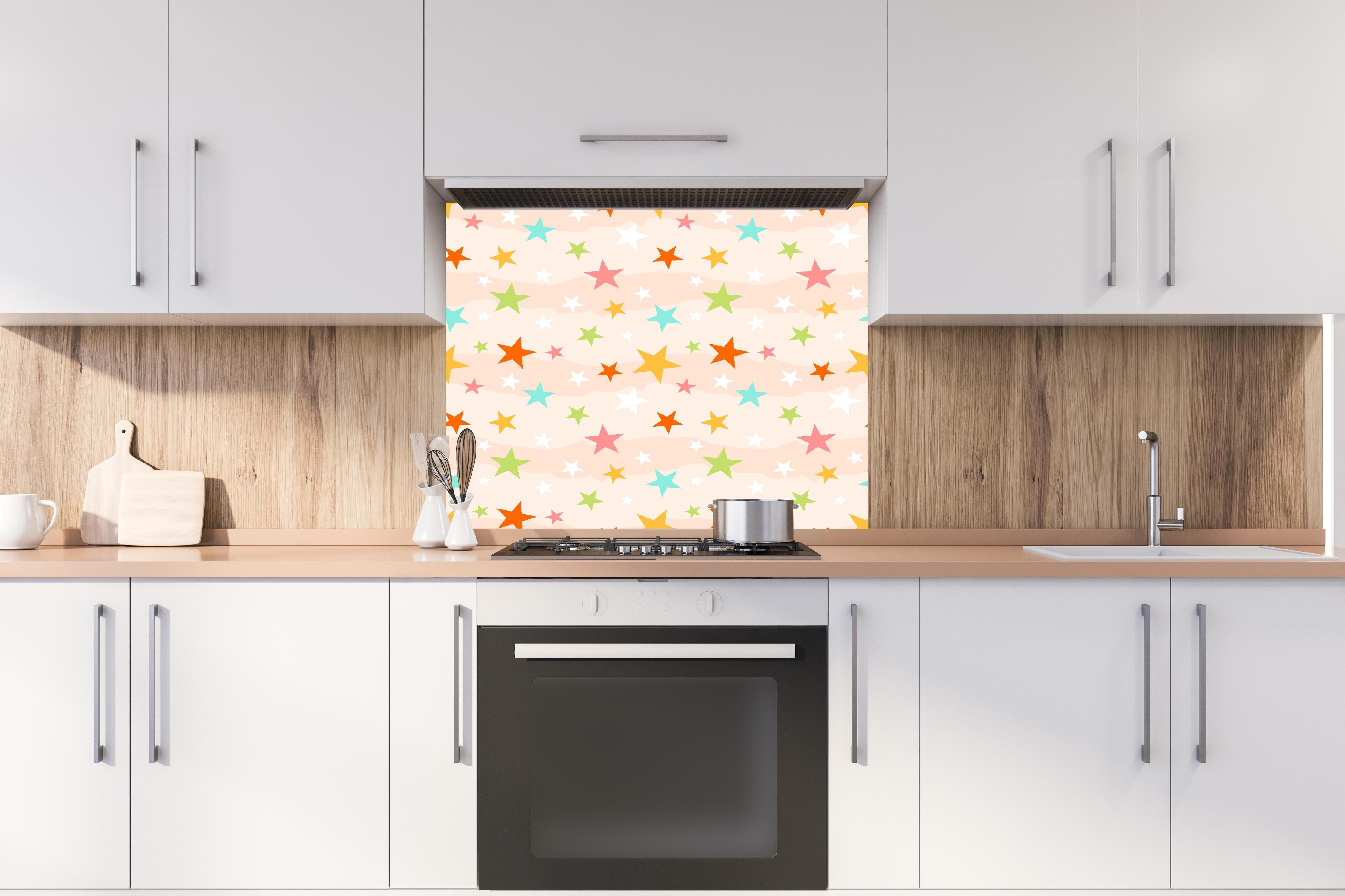 Spritzschutz - Farbenfrohe Sterne Kinderzimmer Tapetenmuster hinter einem Cerankochfeld zwischen Holz-Kochutensilien