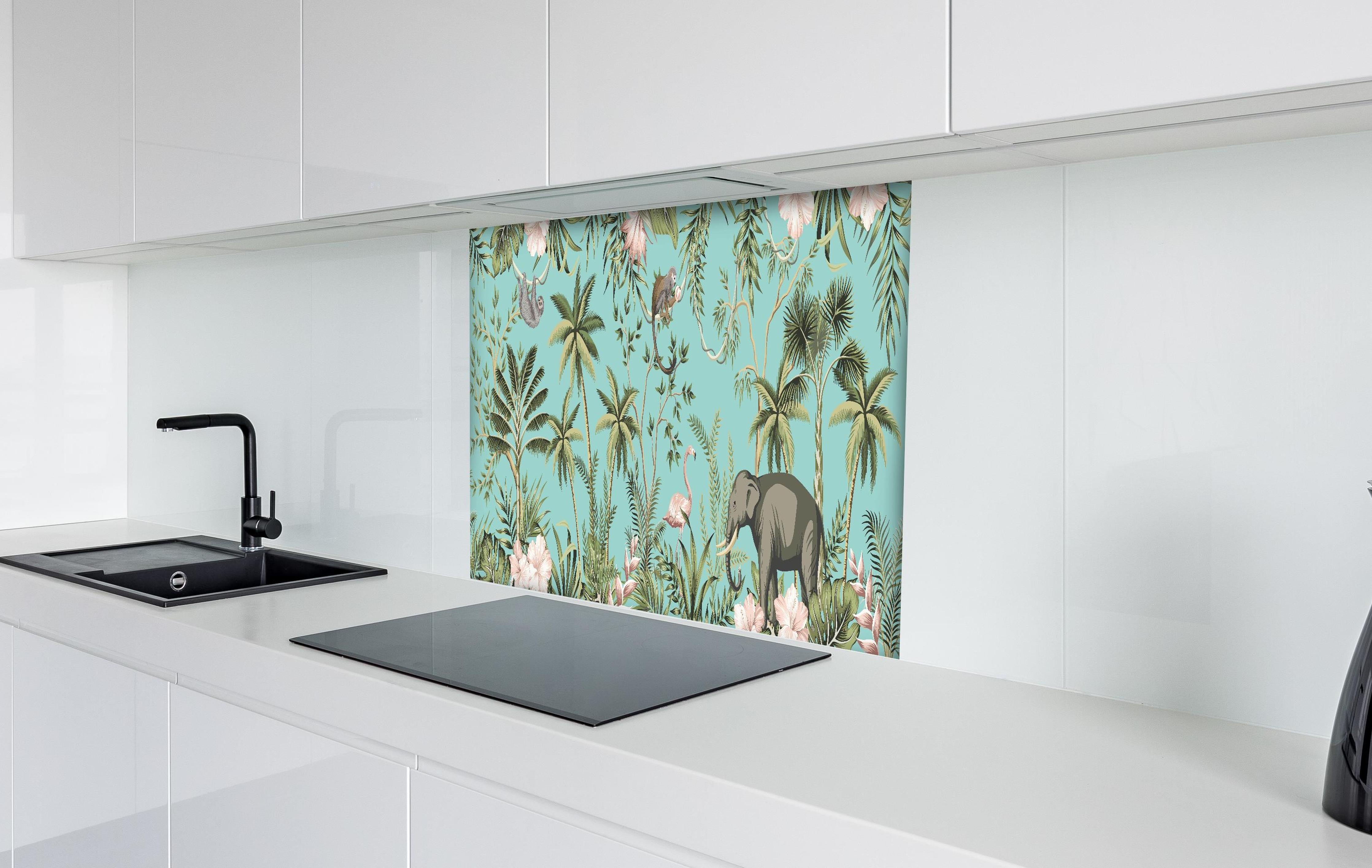 Spritzschutz - Farbenfrohes Dschungel-Muster auf Textil hinter einem Cerankochfeld zwischen Holz-Kochutensilien