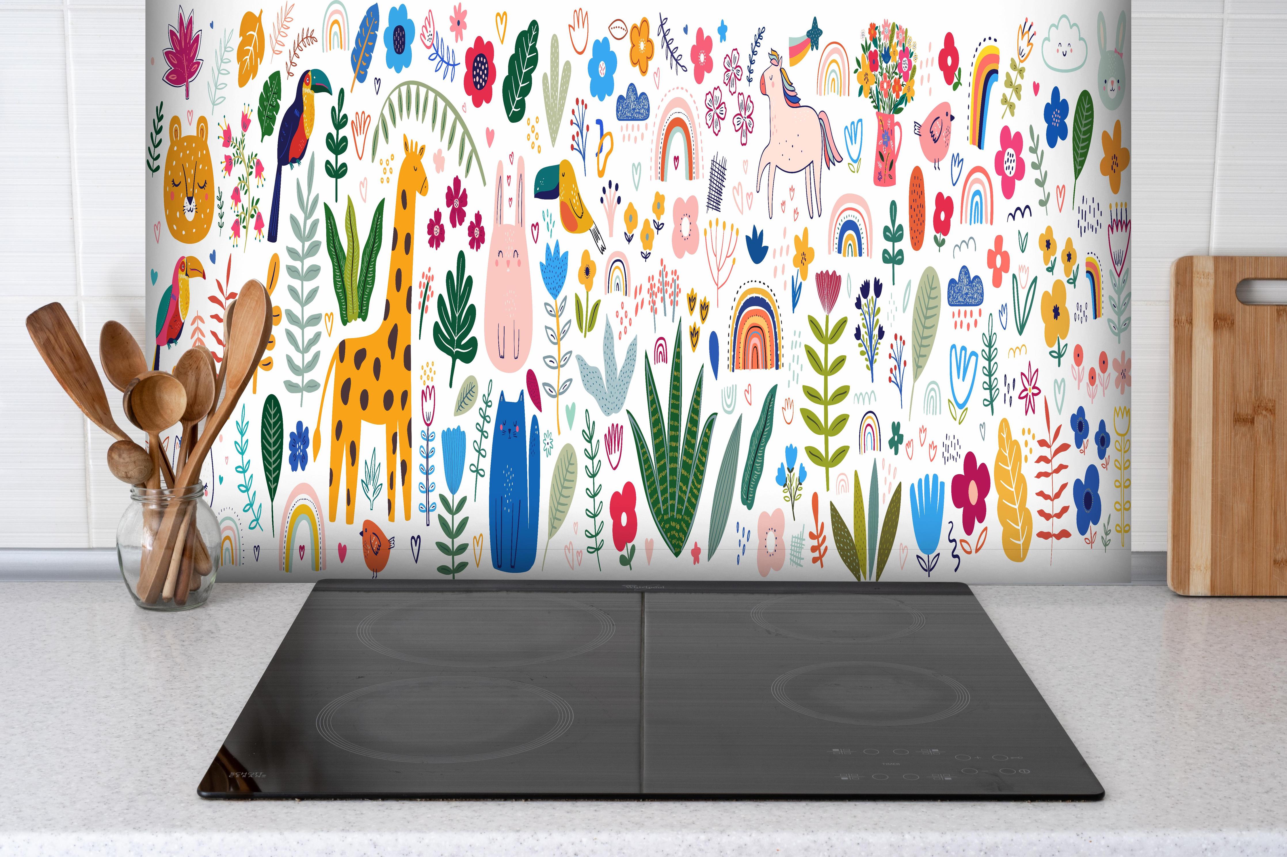 Spritzschutz - Farbenfrohes Muster mit Tieren und Pflanzen hinter einem Cerankochfeld zwischen Holz-Kochutensilien