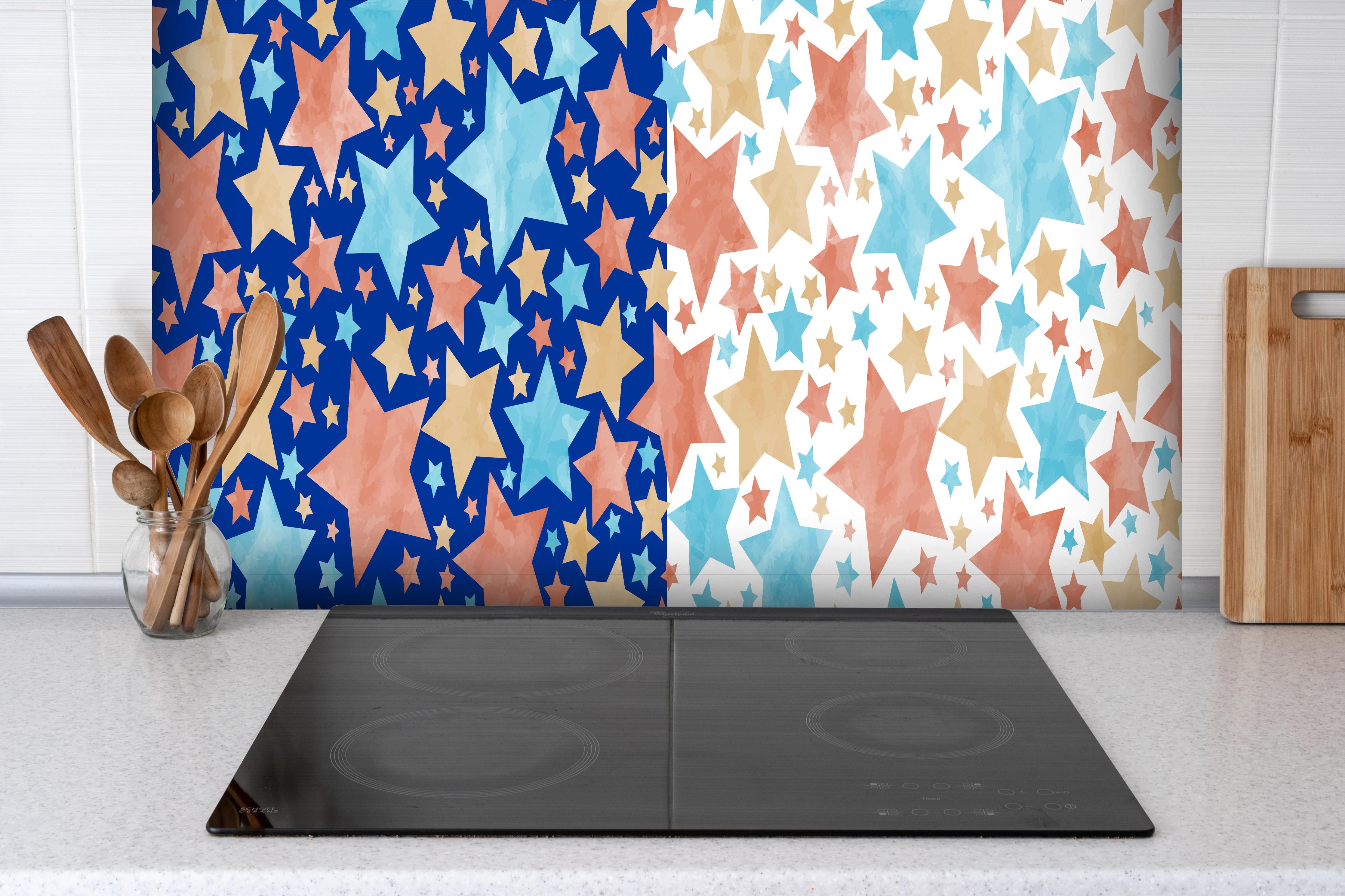 Spritzschutz - Farbenfrohes Sternenmuster Design hinter einem Cerankochfeld zwischen Holz-Kochutensilien