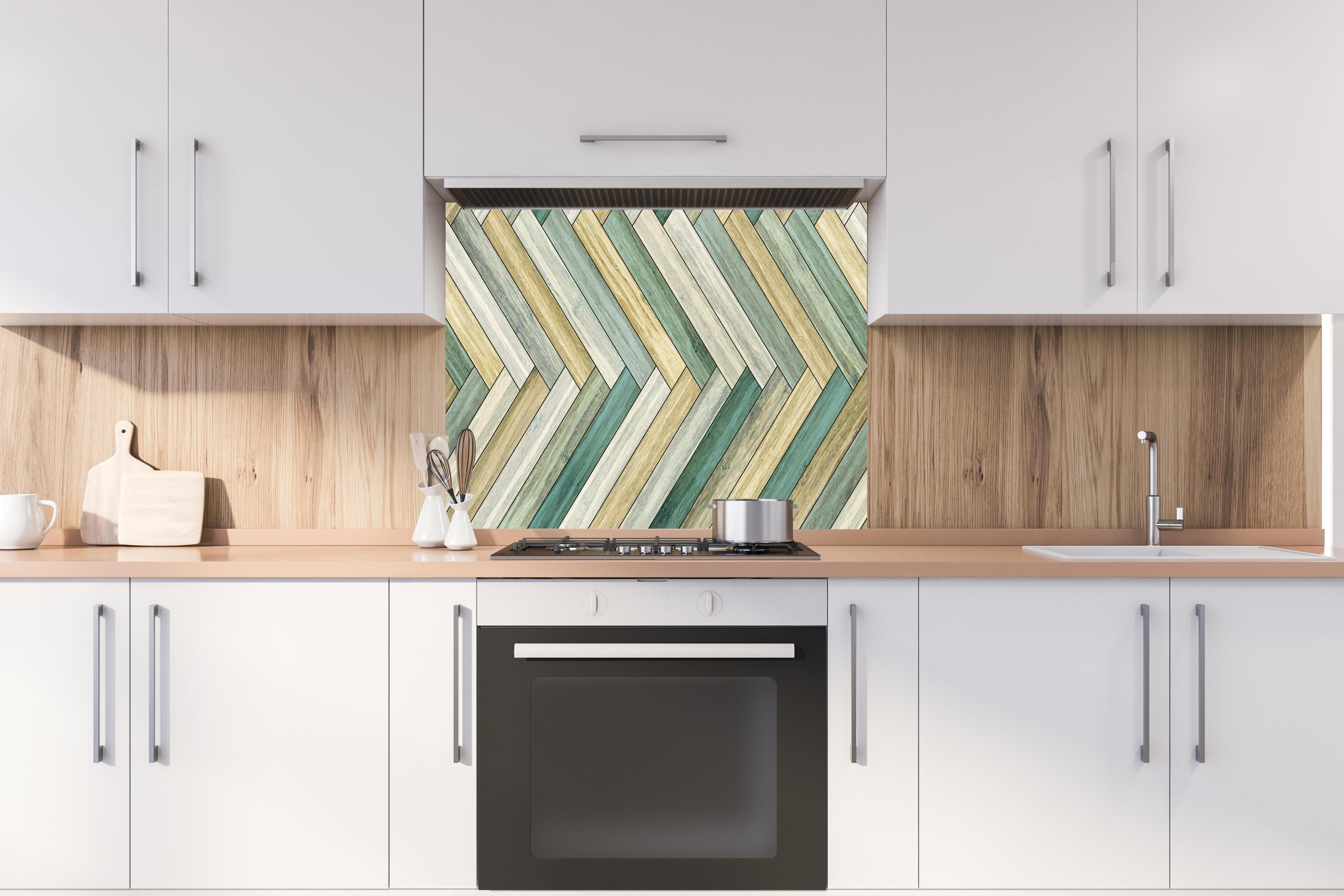 Spritzschutz - Farbenfrohes herringbone Parkettmuster hinter einem Cerankochfeld zwischen Holz-Kochutensilien