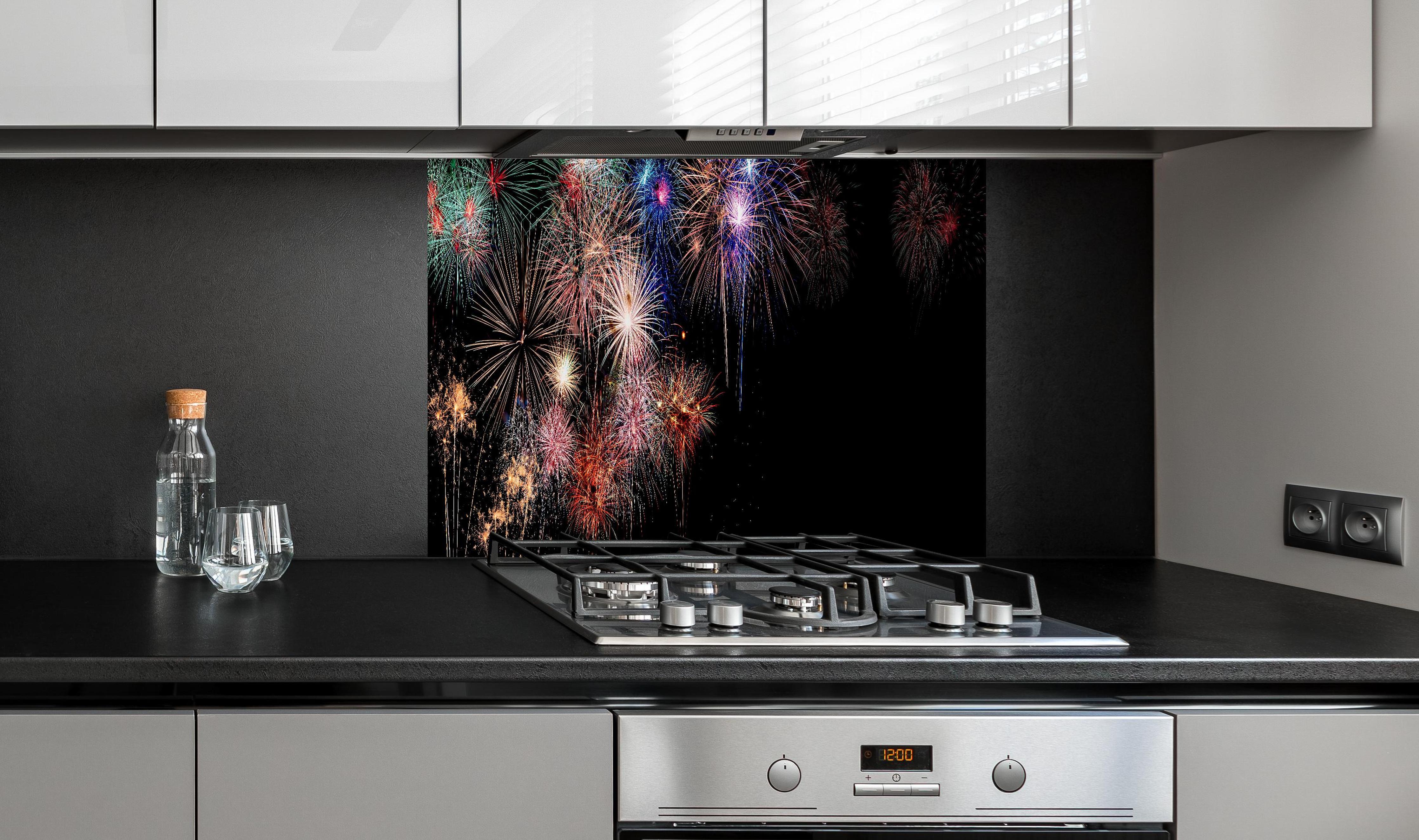 Spritzschutz - Farbenpracht Feuerwerk Happy New Year 2023 hinter einem Cerankochfeld zwischen Holz-Kochutensilien