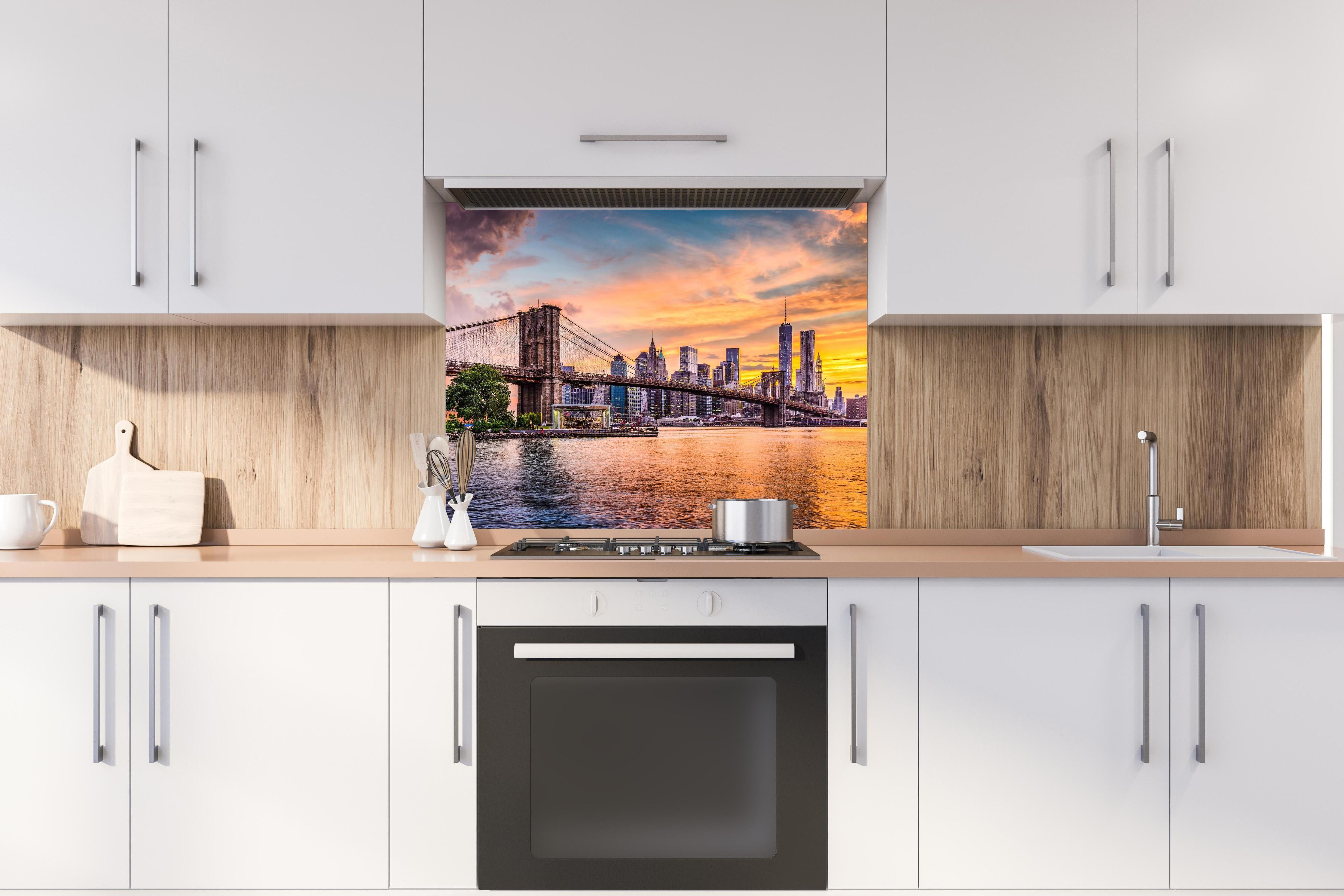 Spritzschutz - Farbenprächtiger Sonnenuntergang über New York hinter einem Cerankochfeld zwischen Holz-Kochutensilien