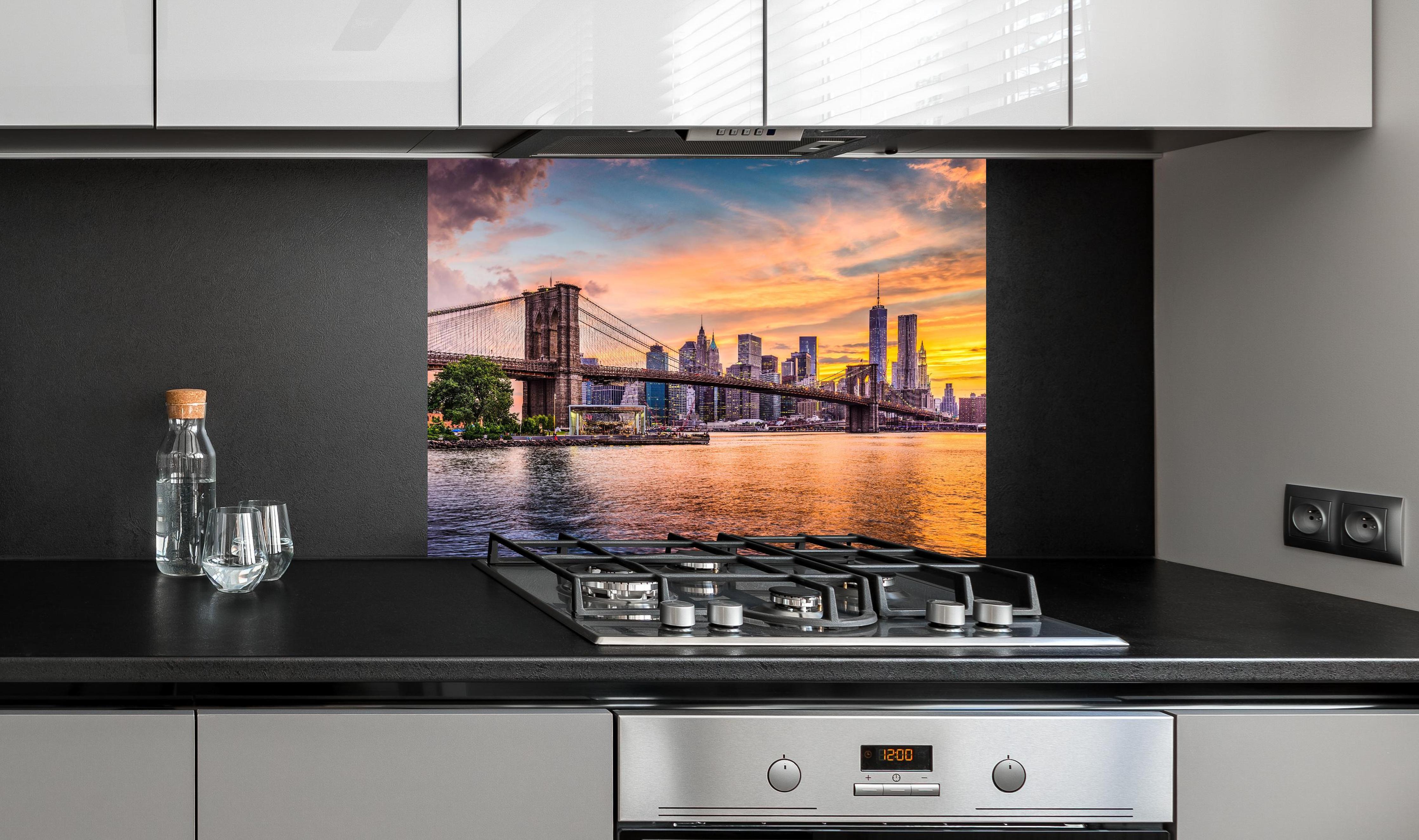 Spritzschutz - Farbenprächtiger Sonnenuntergang über New York hinter einem Cerankochfeld zwischen Holz-Kochutensilien