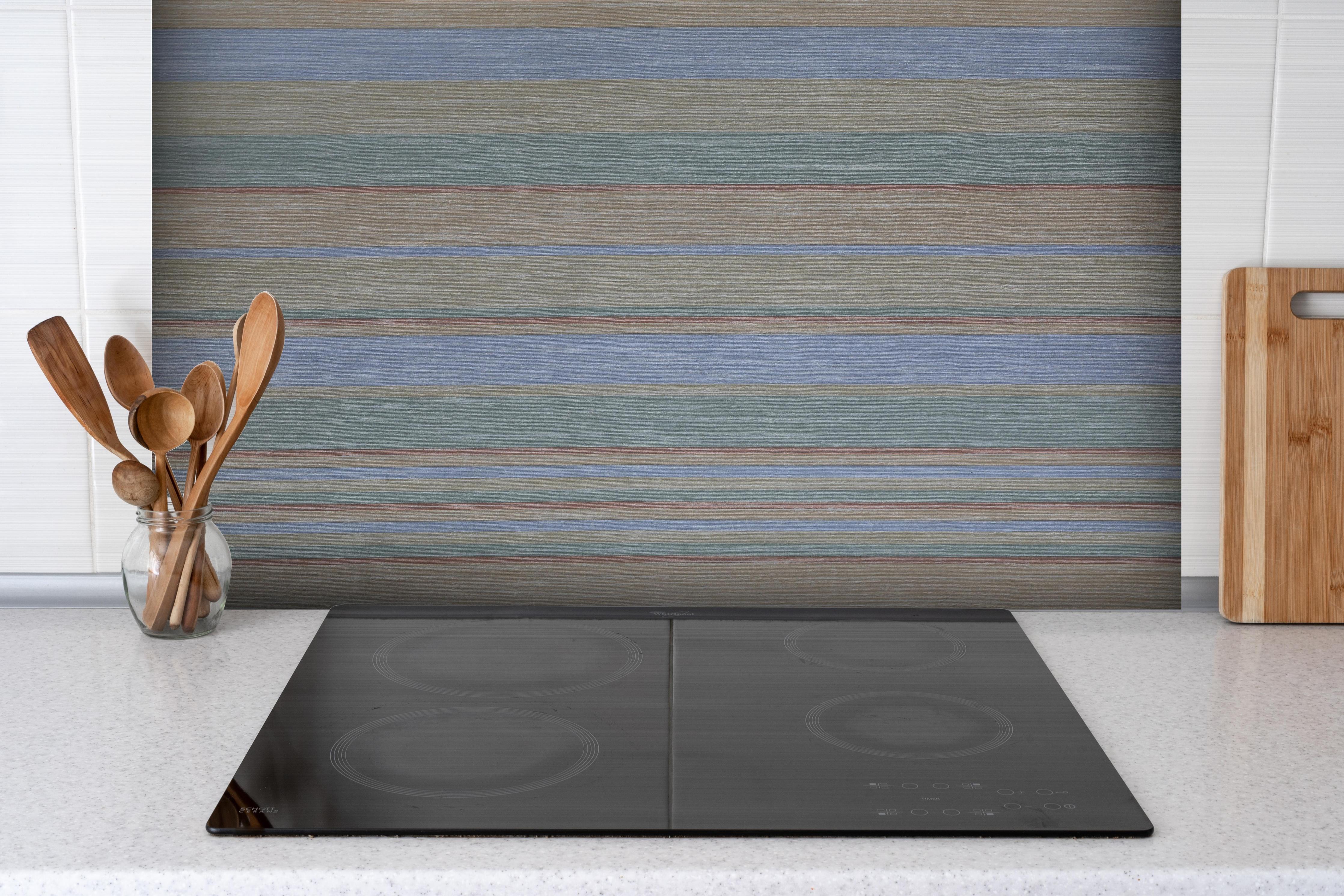 Spritzschutz - Farbiges Grunge-Papier mit Streifenmuster hinter einem Cerankochfeld zwischen Holz-Kochutensilien