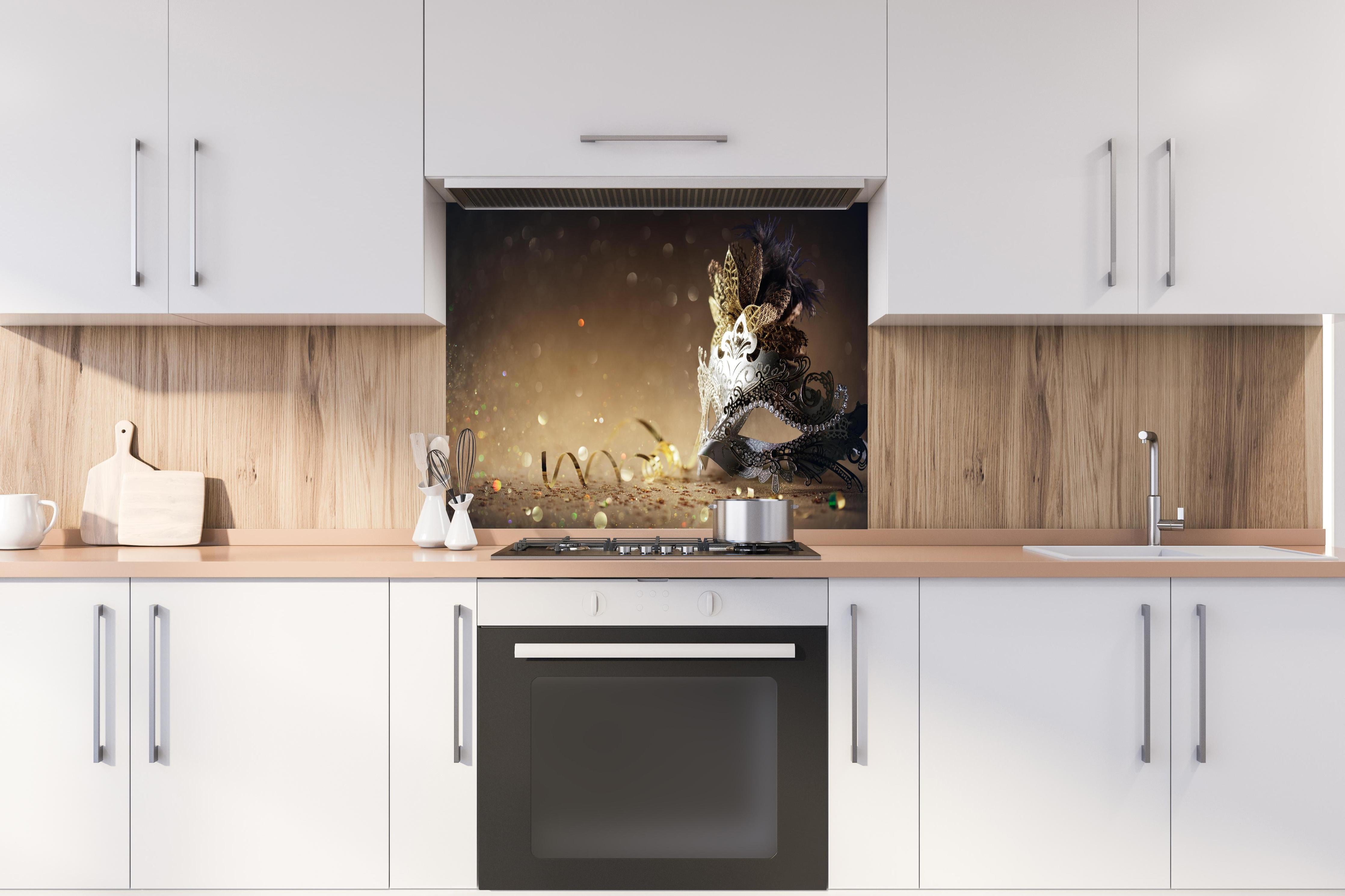 Spritzschutz - Faschingsmaske mit Glitter hinter einem Cerankochfeld zwischen Holz-Kochutensilien