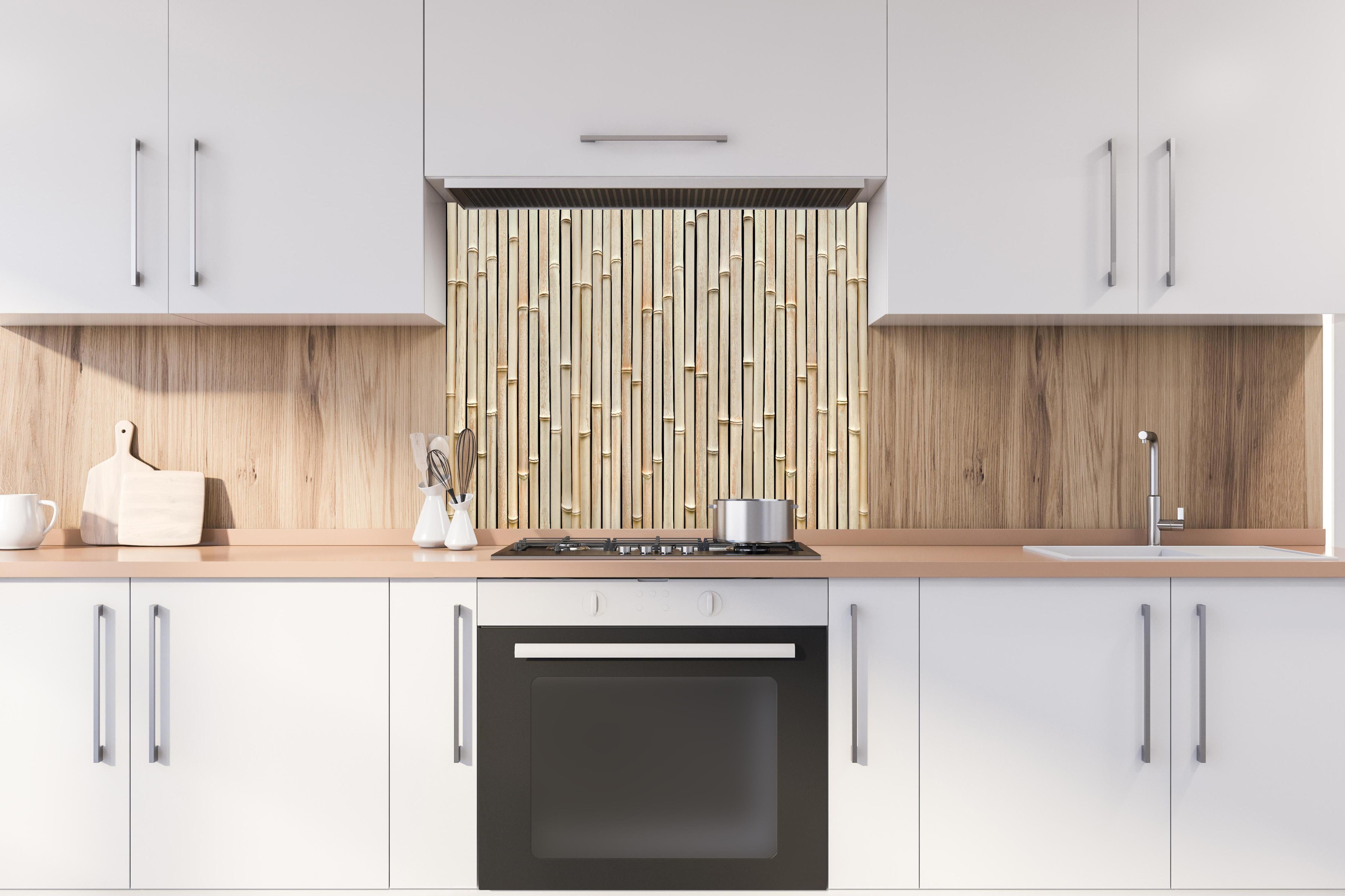 Spritzschutz - Fassade aus schönem Bambus hinter einem Cerankochfeld zwischen Holz-Kochutensilien