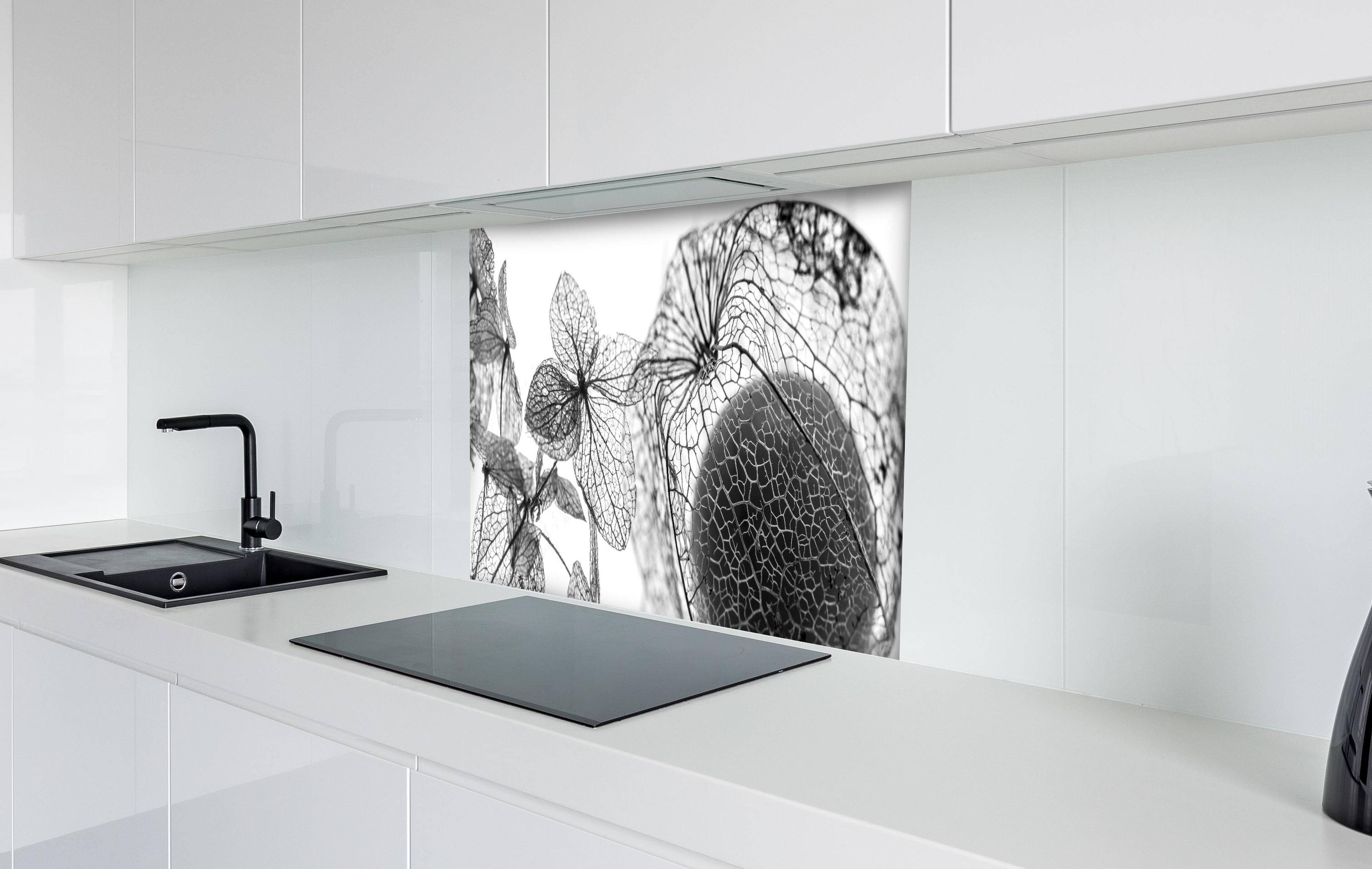 Spritzschutz - Feine Herbstlaub-Struktur in Weiß-Grau hinter einem Cerankochfeld zwischen Holz-Kochutensilien