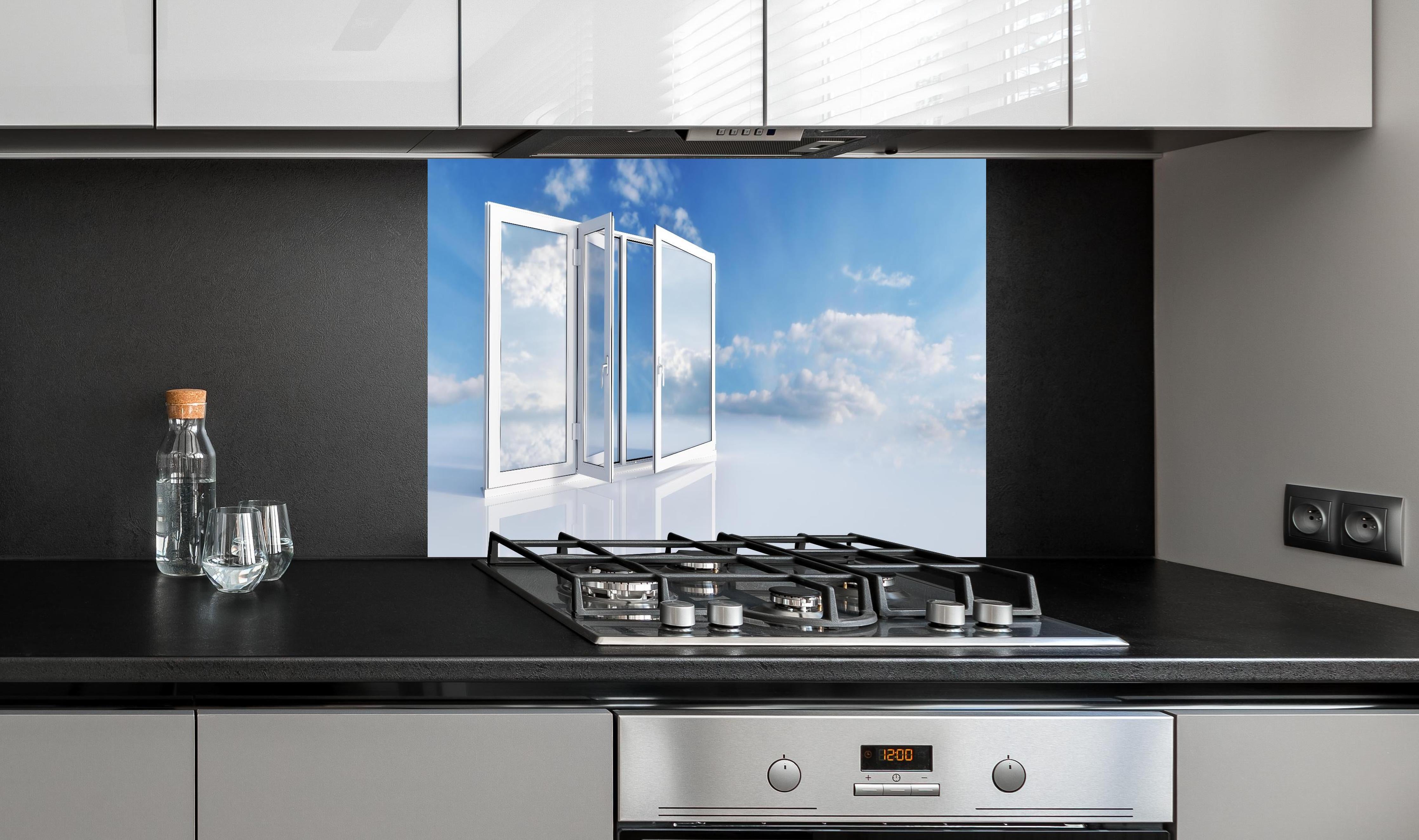 Spritzschutz - Fenster über dem Himmel hinter einem Cerankochfeld zwischen Holz-Kochutensilien