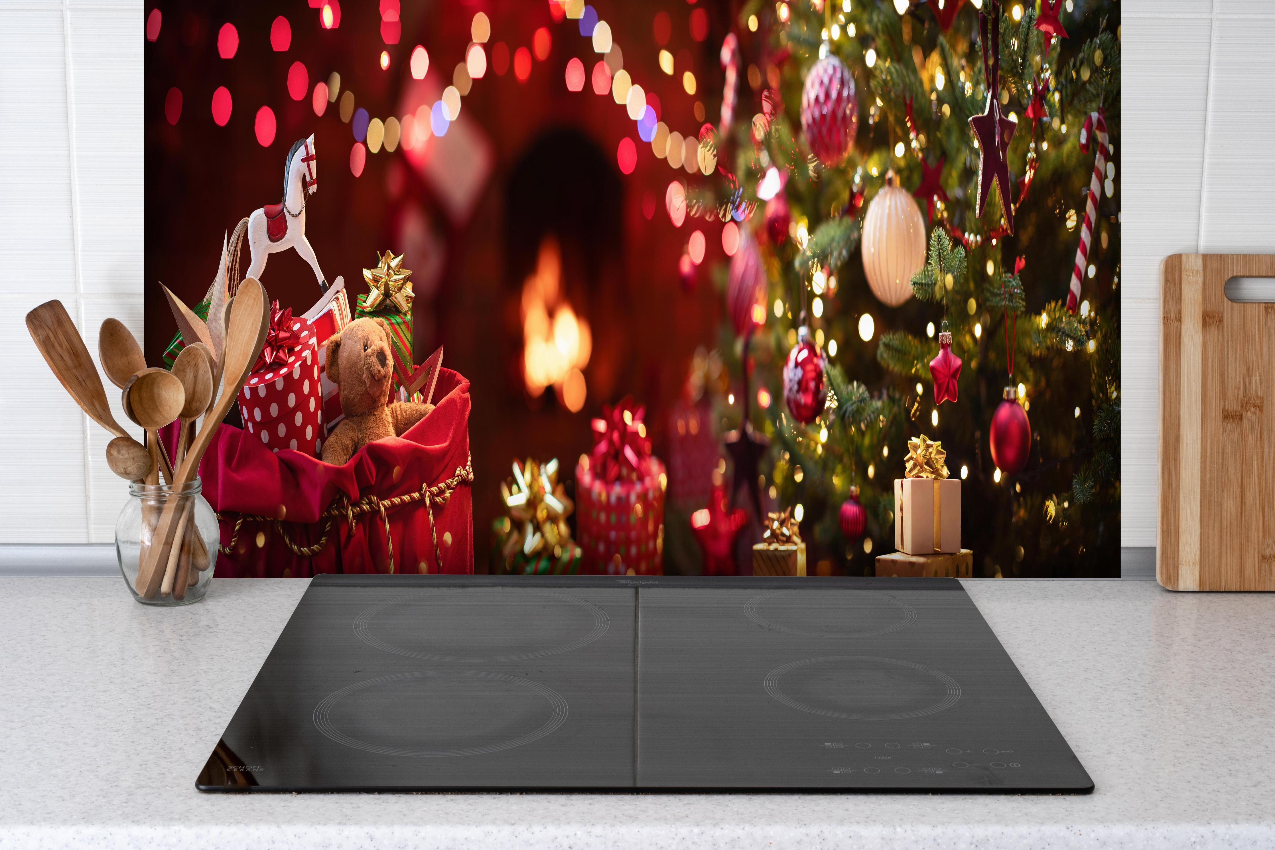 Spritzschutz - Festliche Weihnachtsdeko Rot-Gold Tannenbaum hinter einem Cerankochfeld zwischen Holz-Kochutensilien