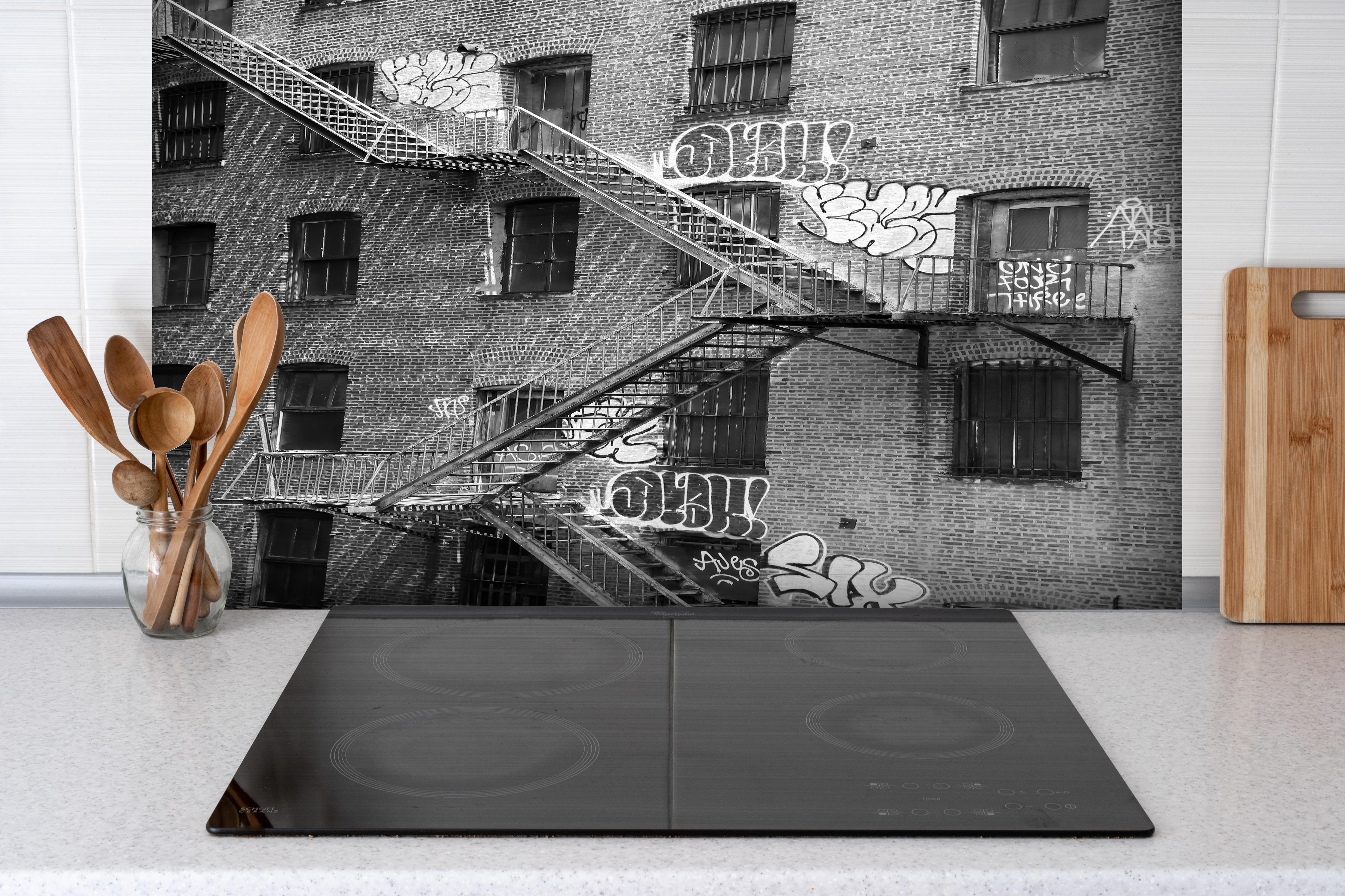 Spritzschutz - Feuerleiter in NYC- USA hinter einem Cerankochfeld zwischen Holz-Kochutensilien