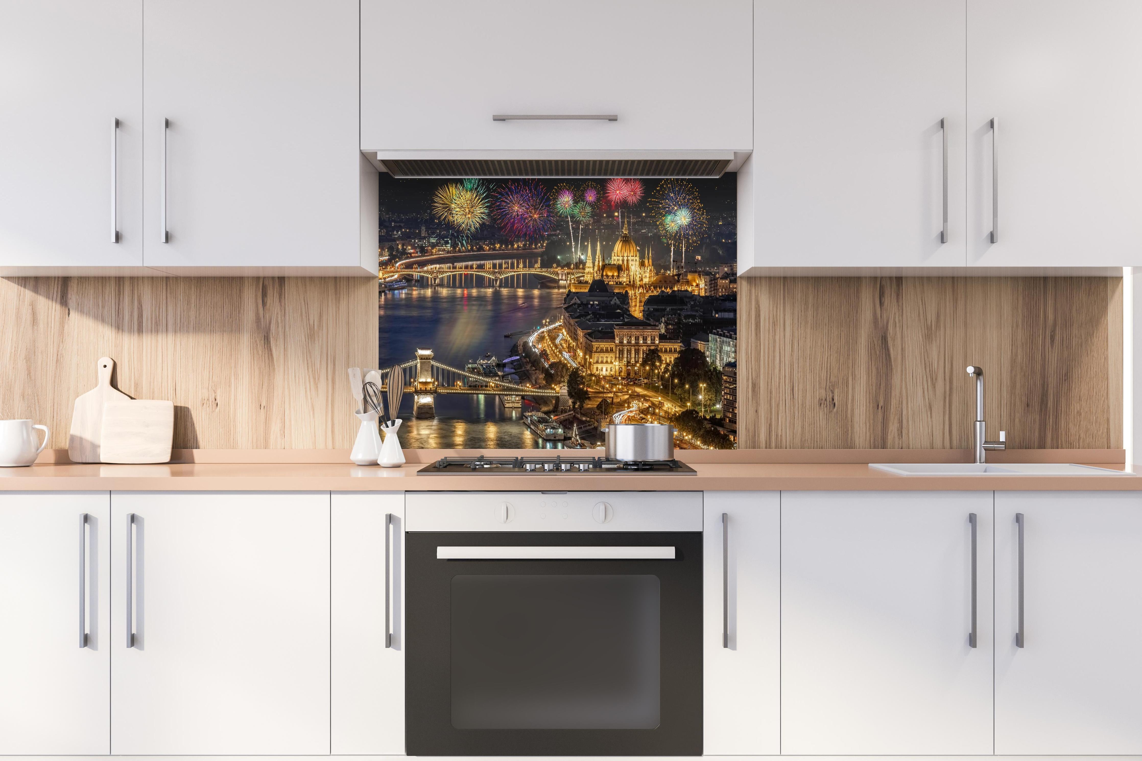 Spritzschutz - Feuerwerk über Budapest bei Nacht hinter einem Cerankochfeld zwischen Holz-Kochutensilien