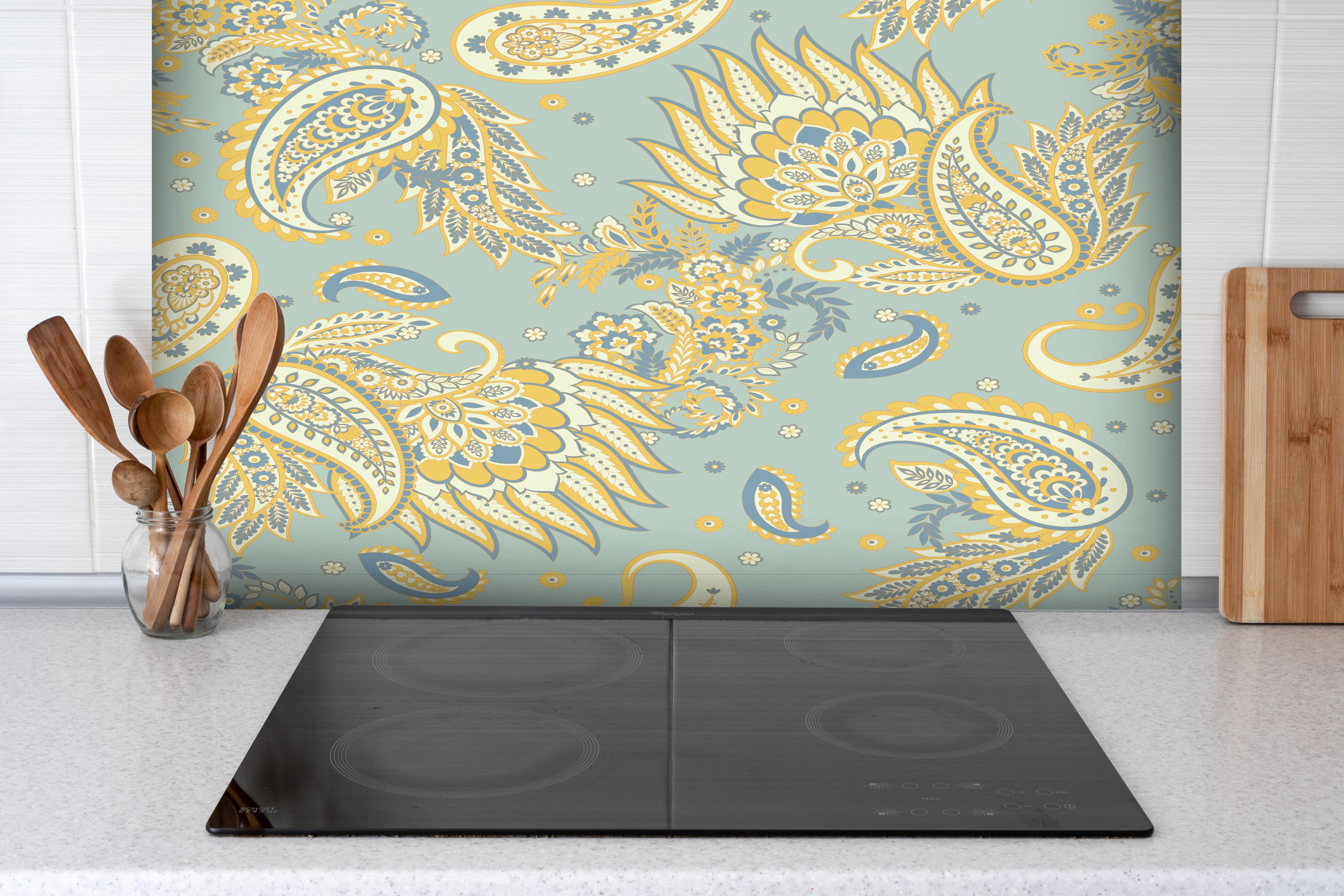 Spritzschutz - Floraler Stoffhintergrund hinter einem Cerankochfeld zwischen Holz-Kochutensilien
