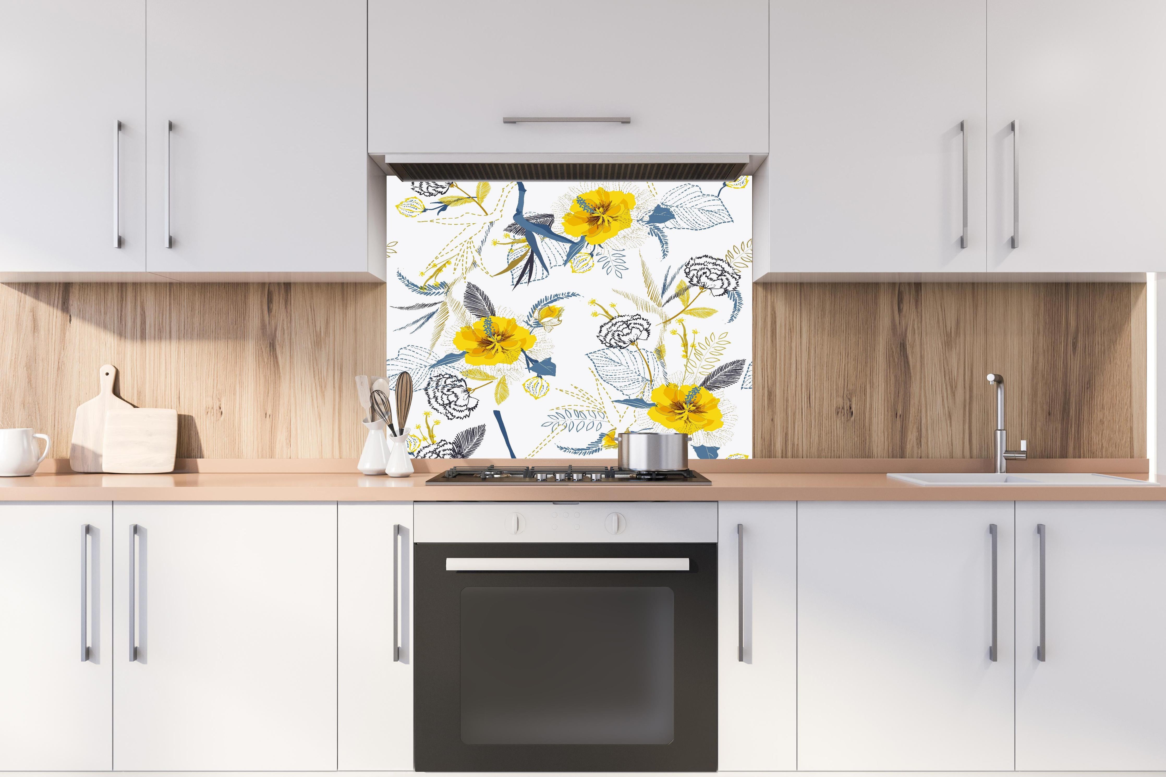 Spritzschutz - Florales Muster mit gelben Akzenten hinter einem Cerankochfeld zwischen Holz-Kochutensilien