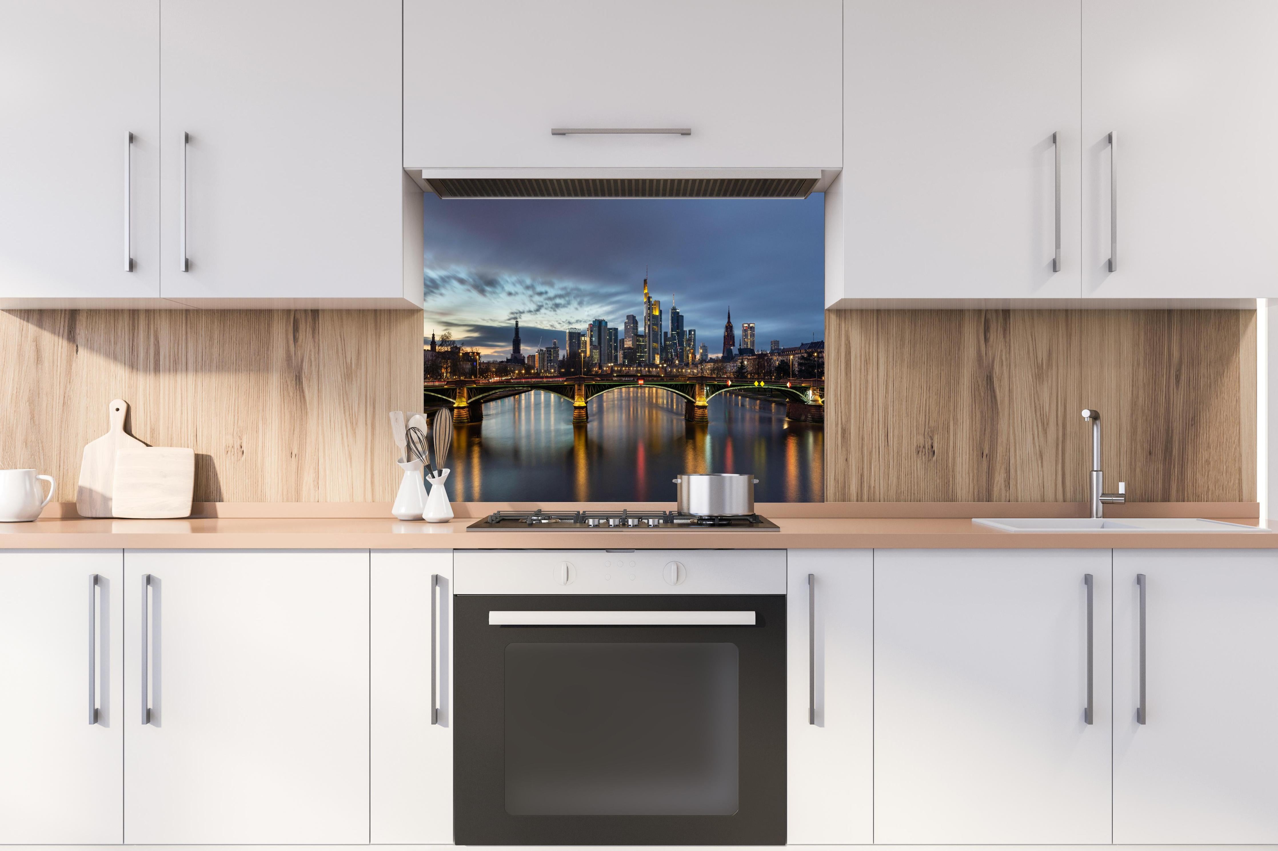 Spritzschutz - Flussansicht in der Dämmerung von Frankfurt hinter einem Cerankochfeld zwischen Holz-Kochutensilien