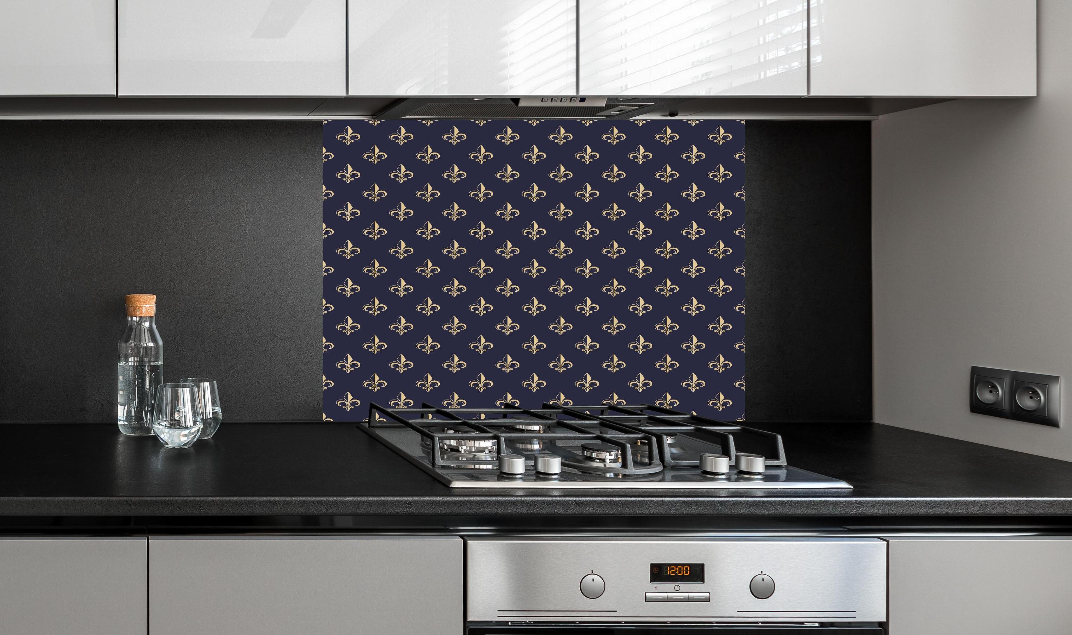 Spritzschutz - Französisches Fleur-de-Lis Design in Dunkelblau hinter einem Cerankochfeld zwischen Holz-Kochutensilien
