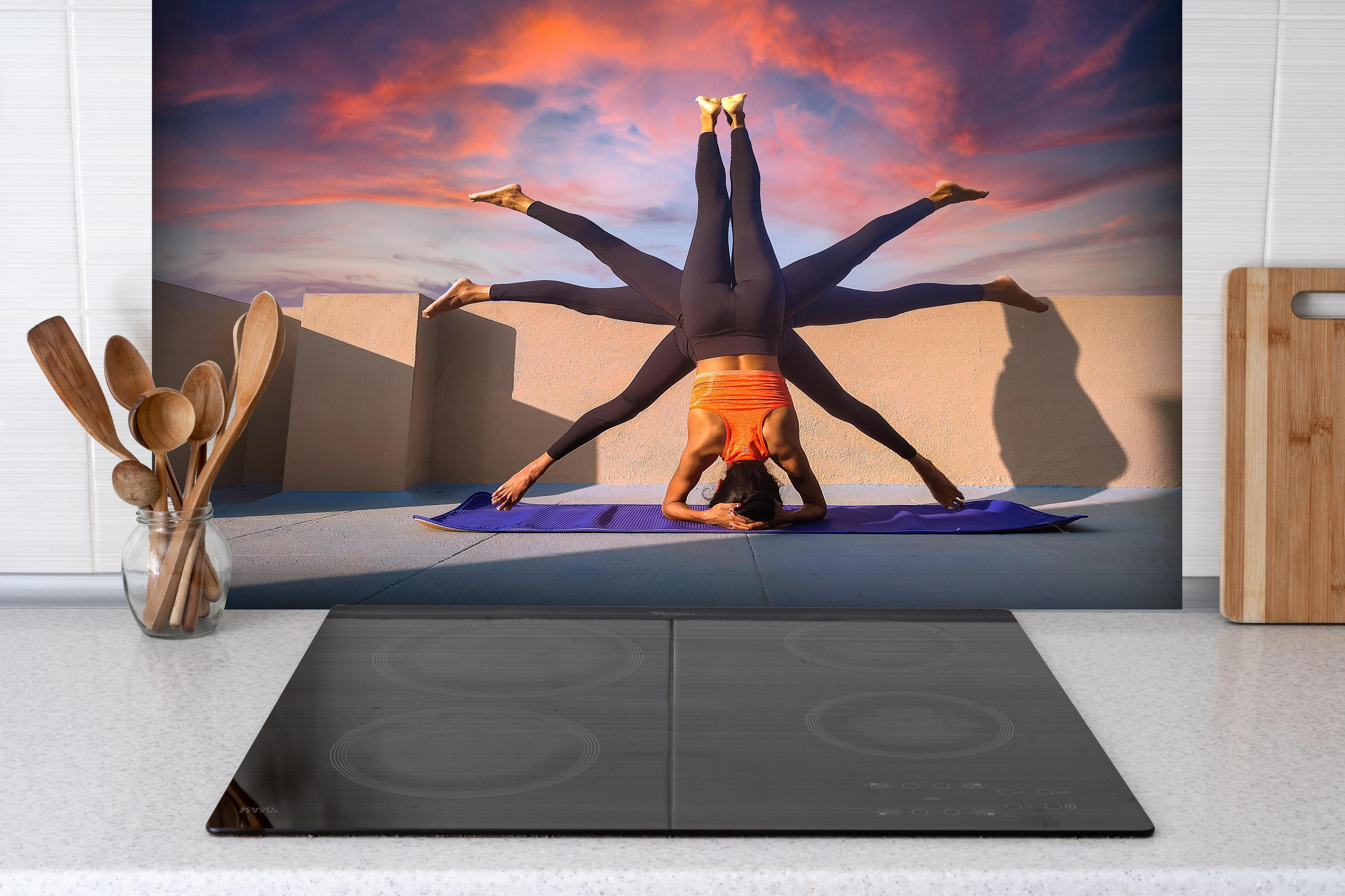 Spritzschutz - Frau Kopfstand verschiedene Posen Spirituell hinter einem Cerankochfeld zwischen Holz-Kochutensilien