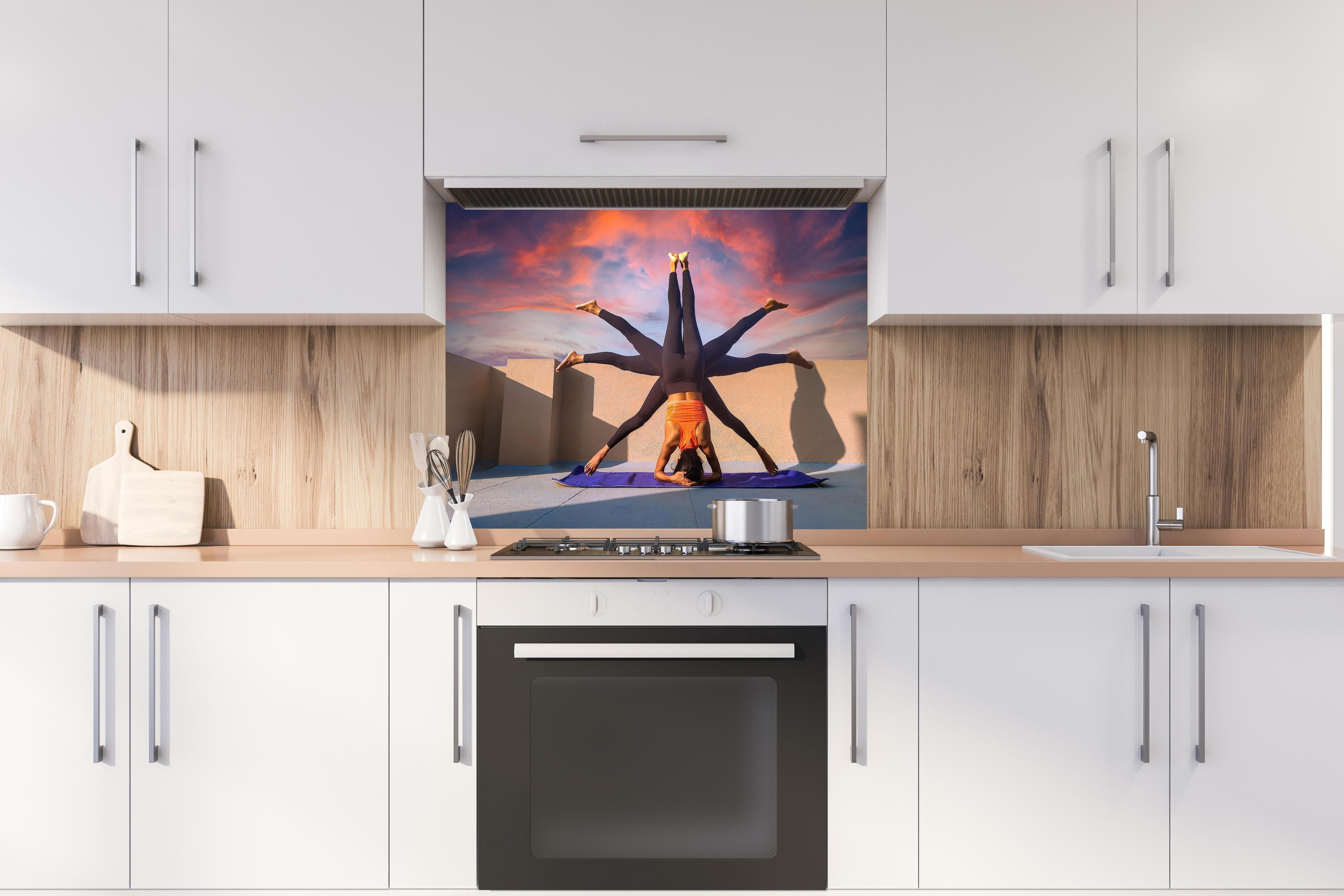 Spritzschutz - Frau Kopfstand verschiedene Posen Spirituell hinter einem Cerankochfeld zwischen Holz-Kochutensilien