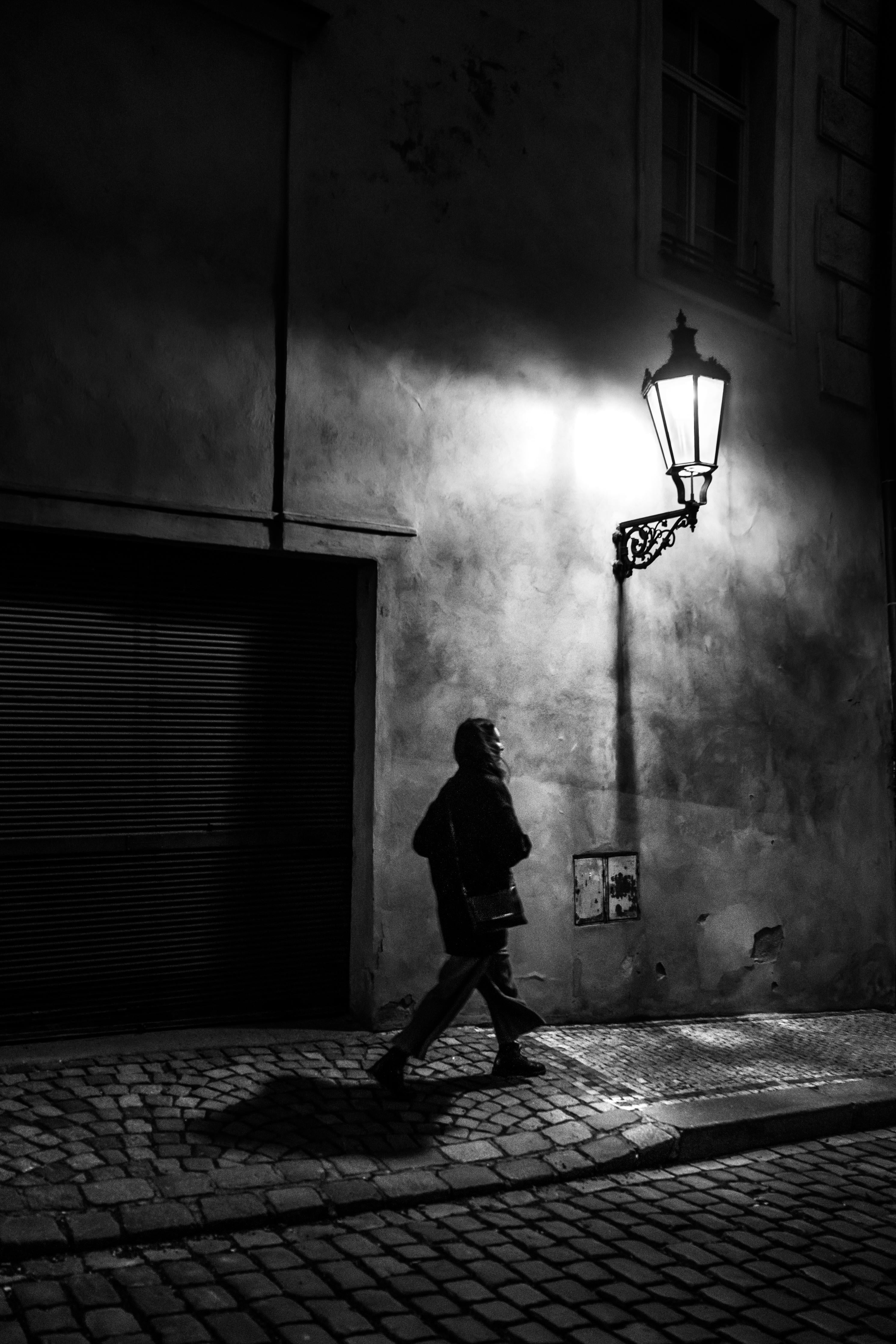 Spritzschutz-Frau im urbanen Nachtschatten Schwarz-Weiß