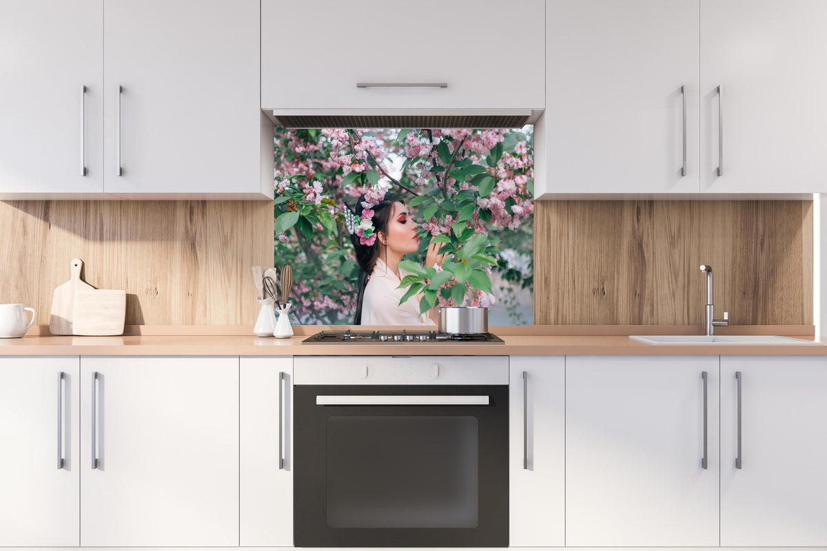 Spritzschutz - Frau in Kimono genießt Sakura-Garten hinter einem Cerankochfeld zwischen Holz-Kochutensilien