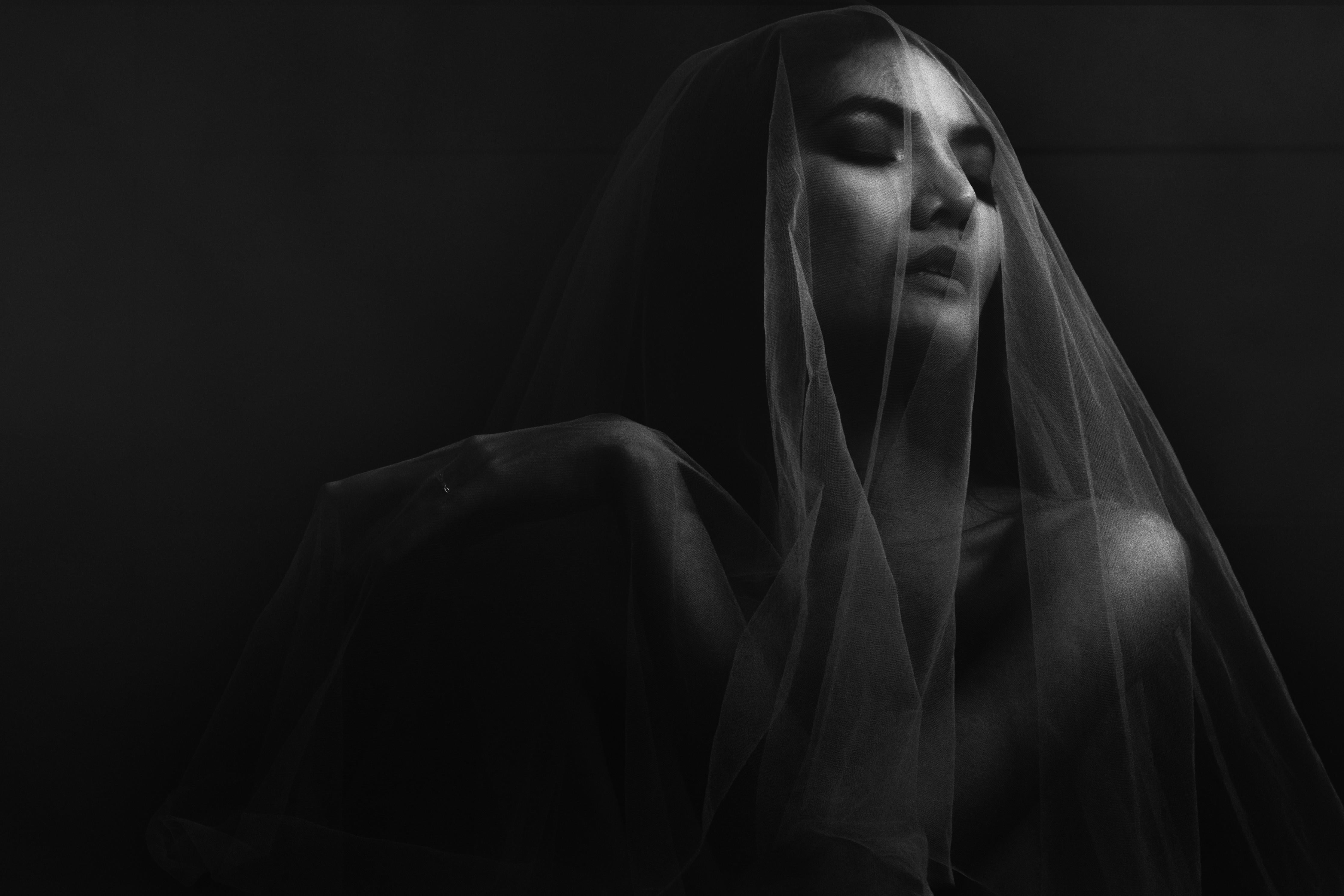 Spritzschutz-Frau unter einem Schleier im dunkeln