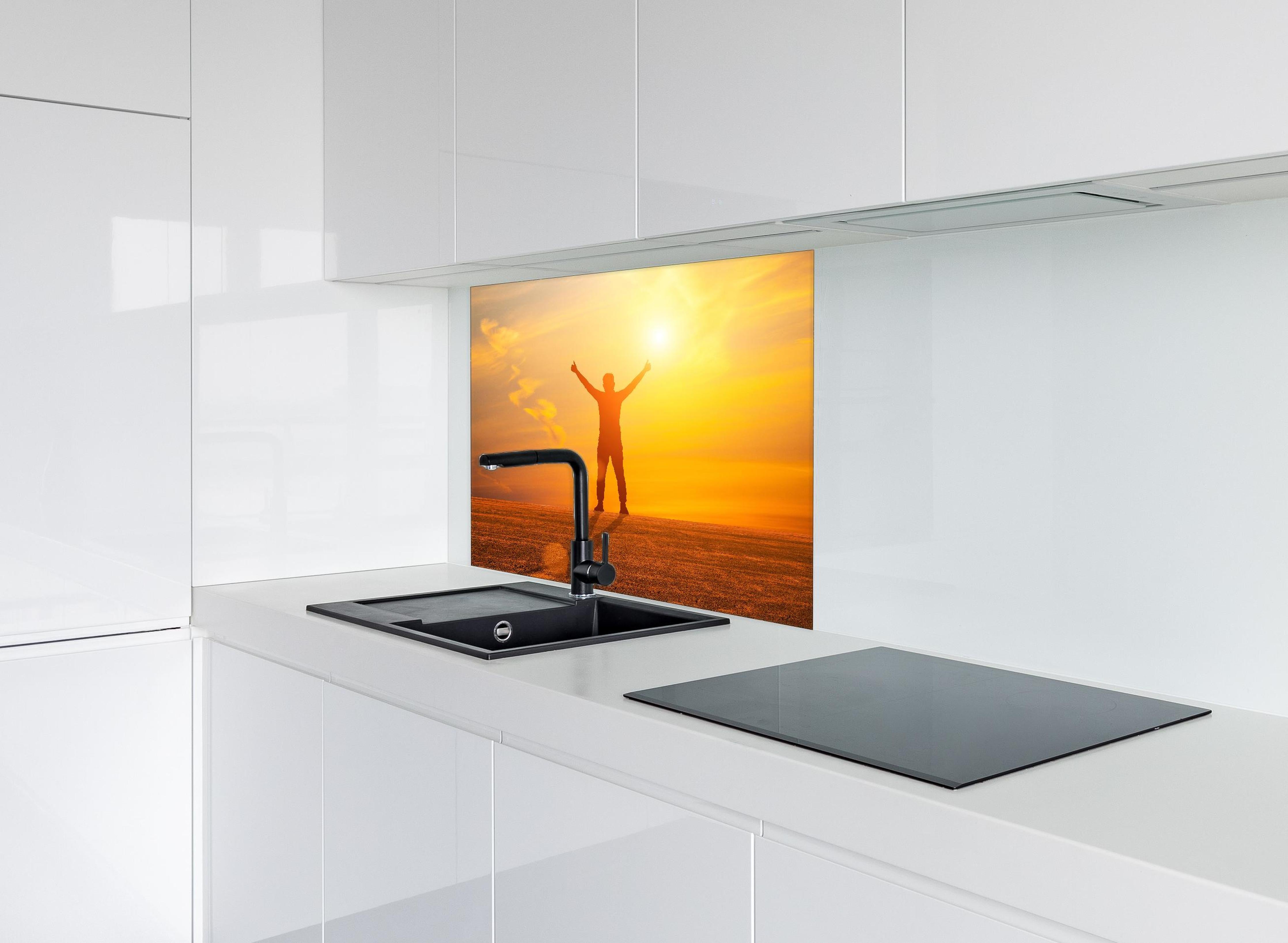 Spritzschutz - Freier Mann im goldenen Licht der Sonne hinter einem Cerankochfeld zwischen Holz-Kochutensilien