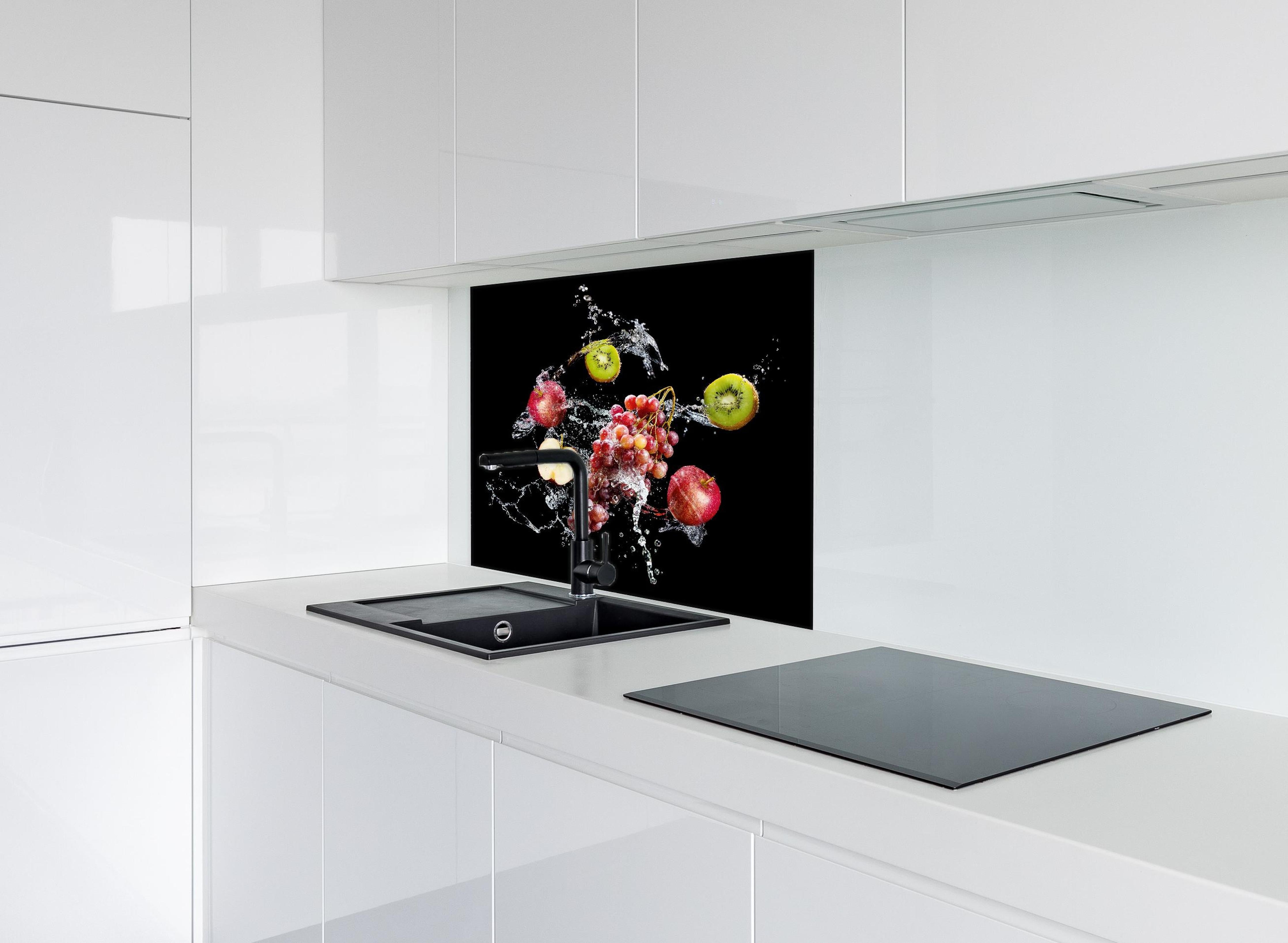 Spritzschutz - Frische Früchte im Wasser-Splash auf Schwarz hinter einem Cerankochfeld zwischen Holz-Kochutensilien