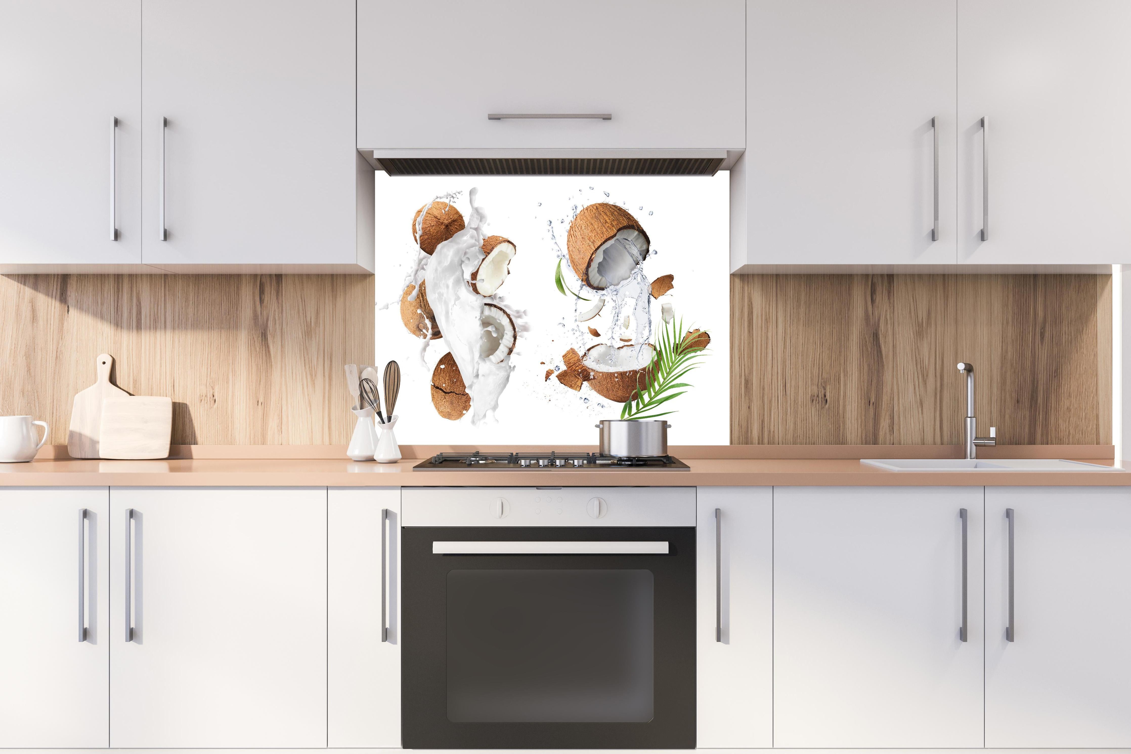 Spritzschutz - Frische Kokosnüsse hinter einem Cerankochfeld zwischen Holz-Kochutensilien