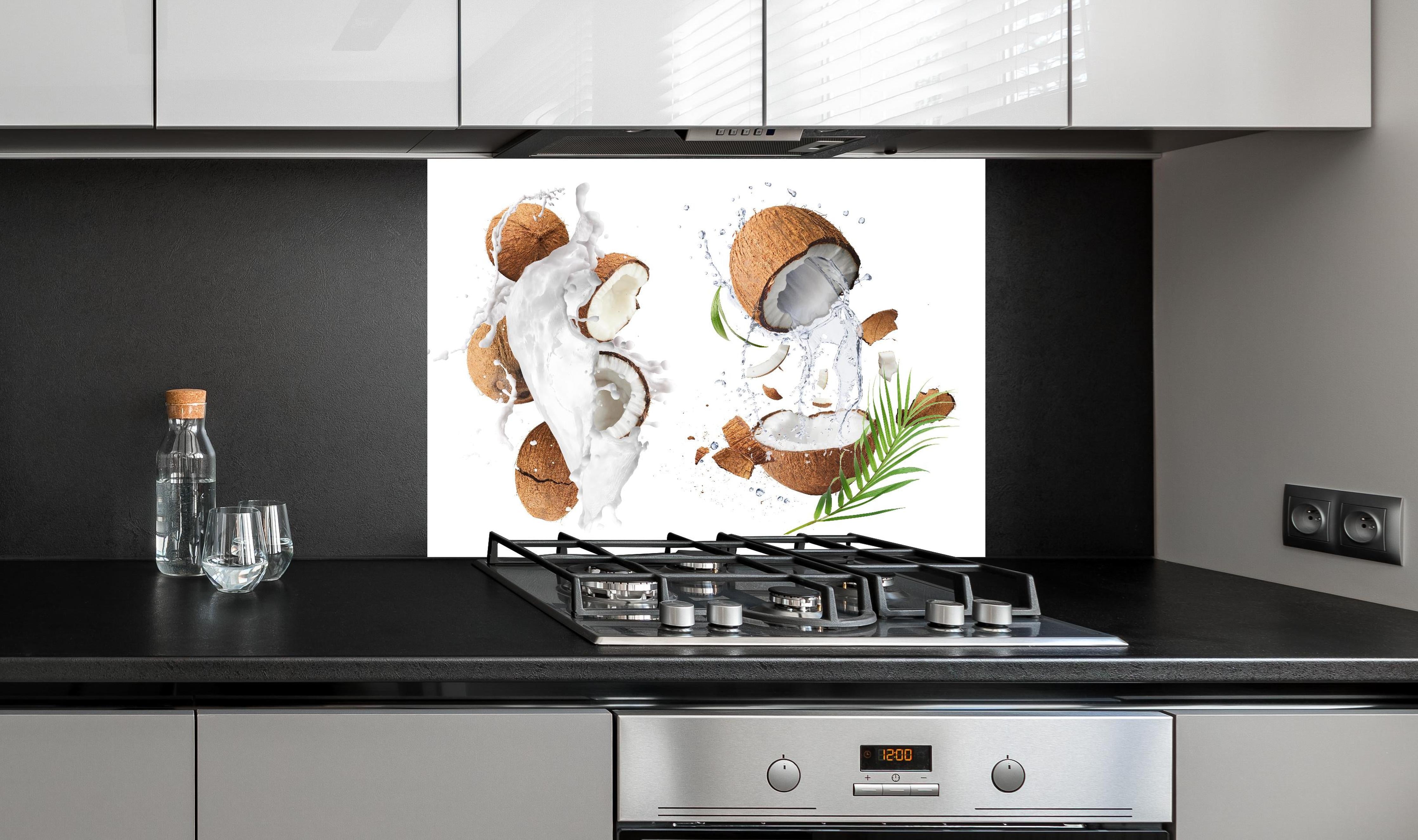 Spritzschutz - Frische Kokosnüsse hinter einem Cerankochfeld zwischen Holz-Kochutensilien