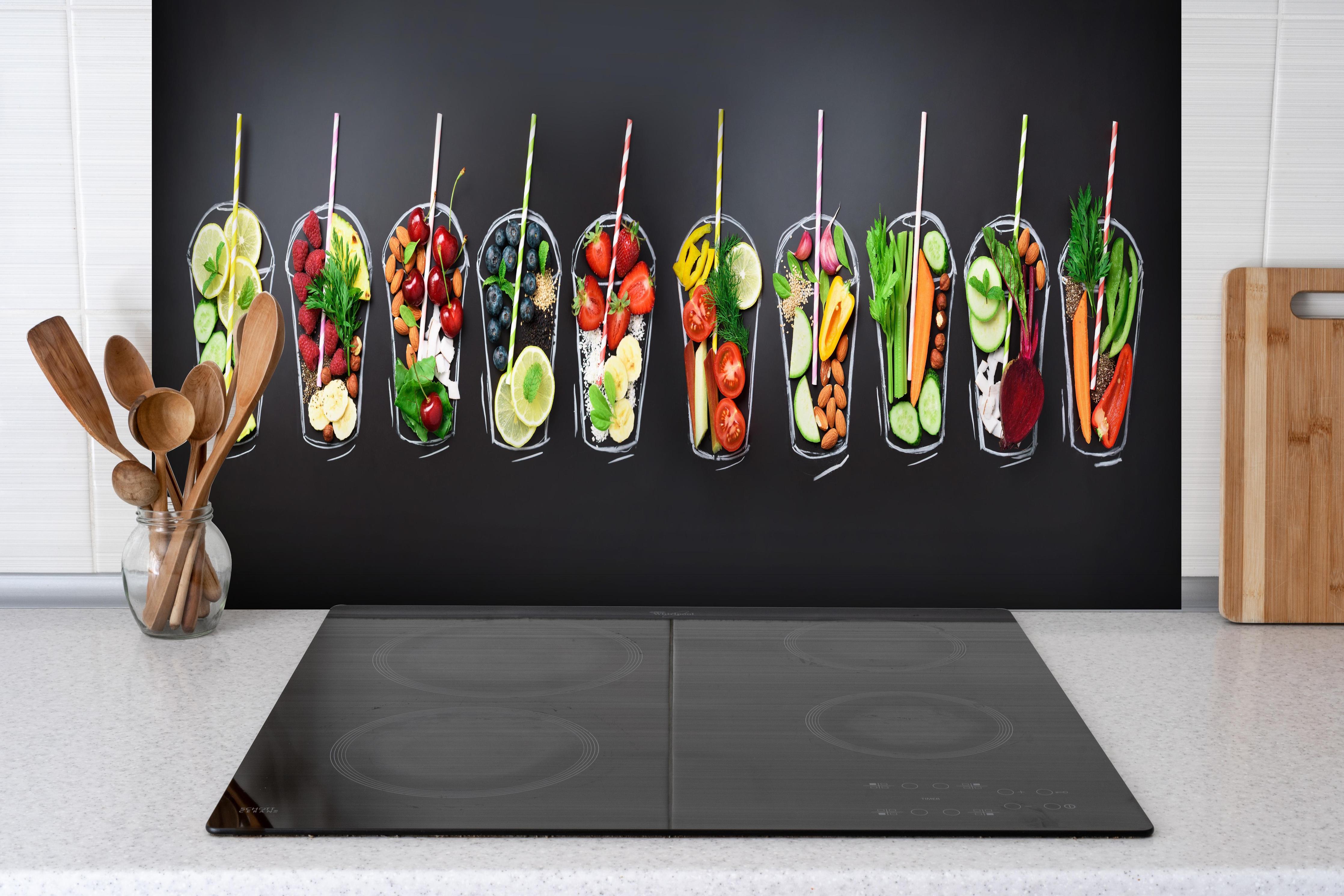 Spritzschutz - Frische Smoothie Zutaten auf Schwarz hinter einem Cerankochfeld zwischen Holz-Kochutensilien