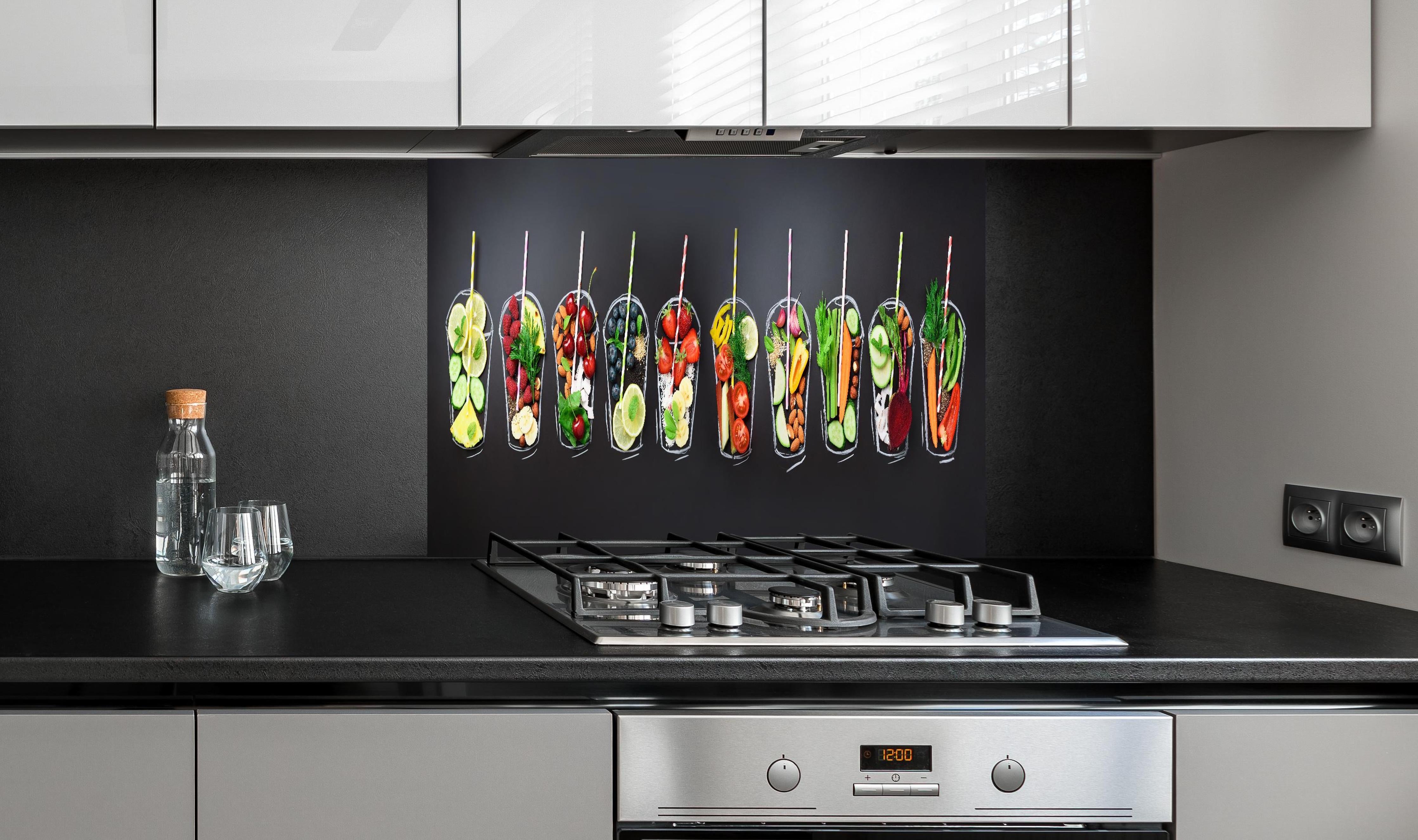 Spritzschutz - Frische Smoothie Zutaten auf Schwarz hinter einem Cerankochfeld zwischen Holz-Kochutensilien