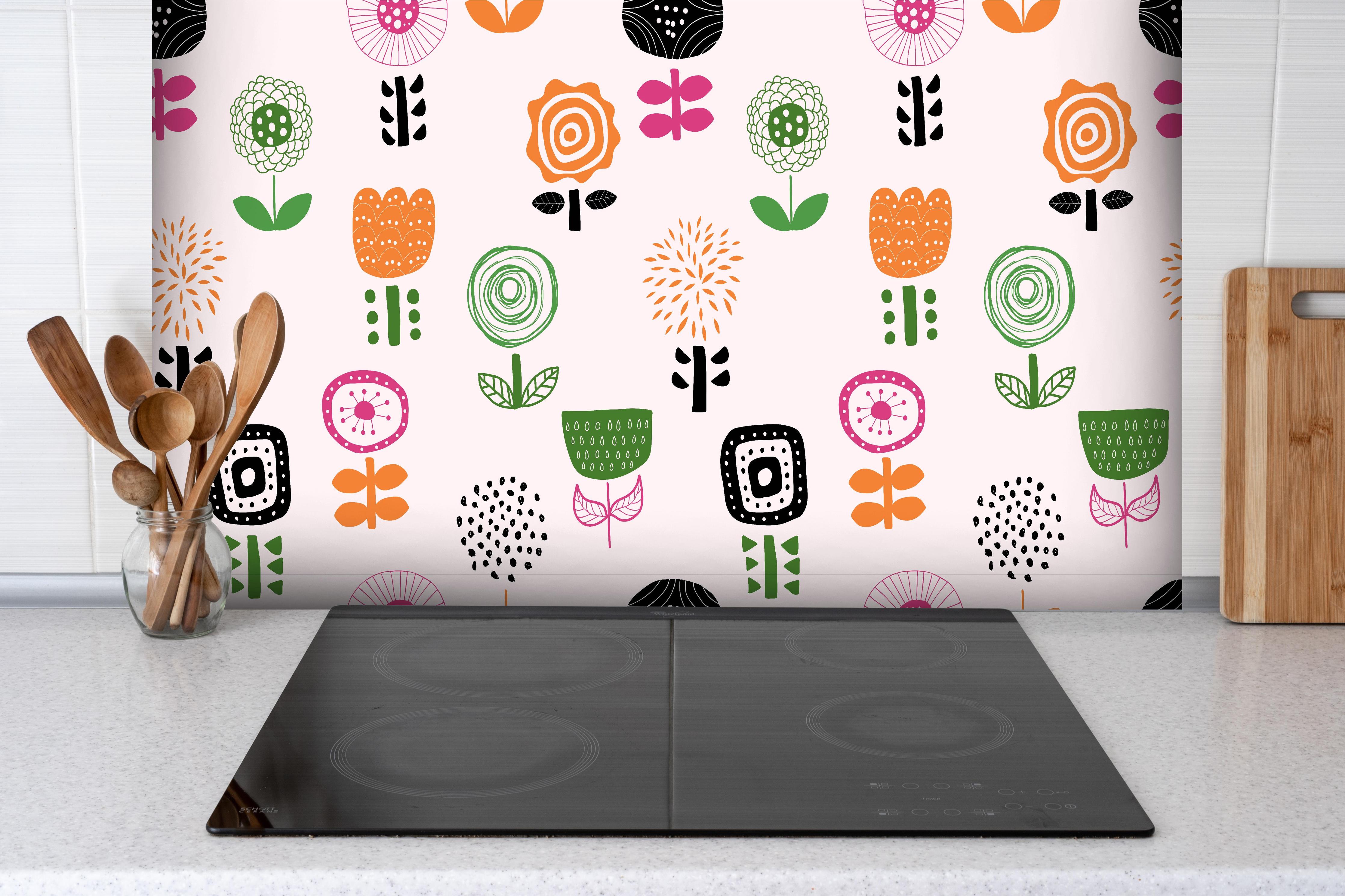 Spritzschutz - Fröhliches Retro Blumenmuster Textil hinter einem Cerankochfeld zwischen Holz-Kochutensilien