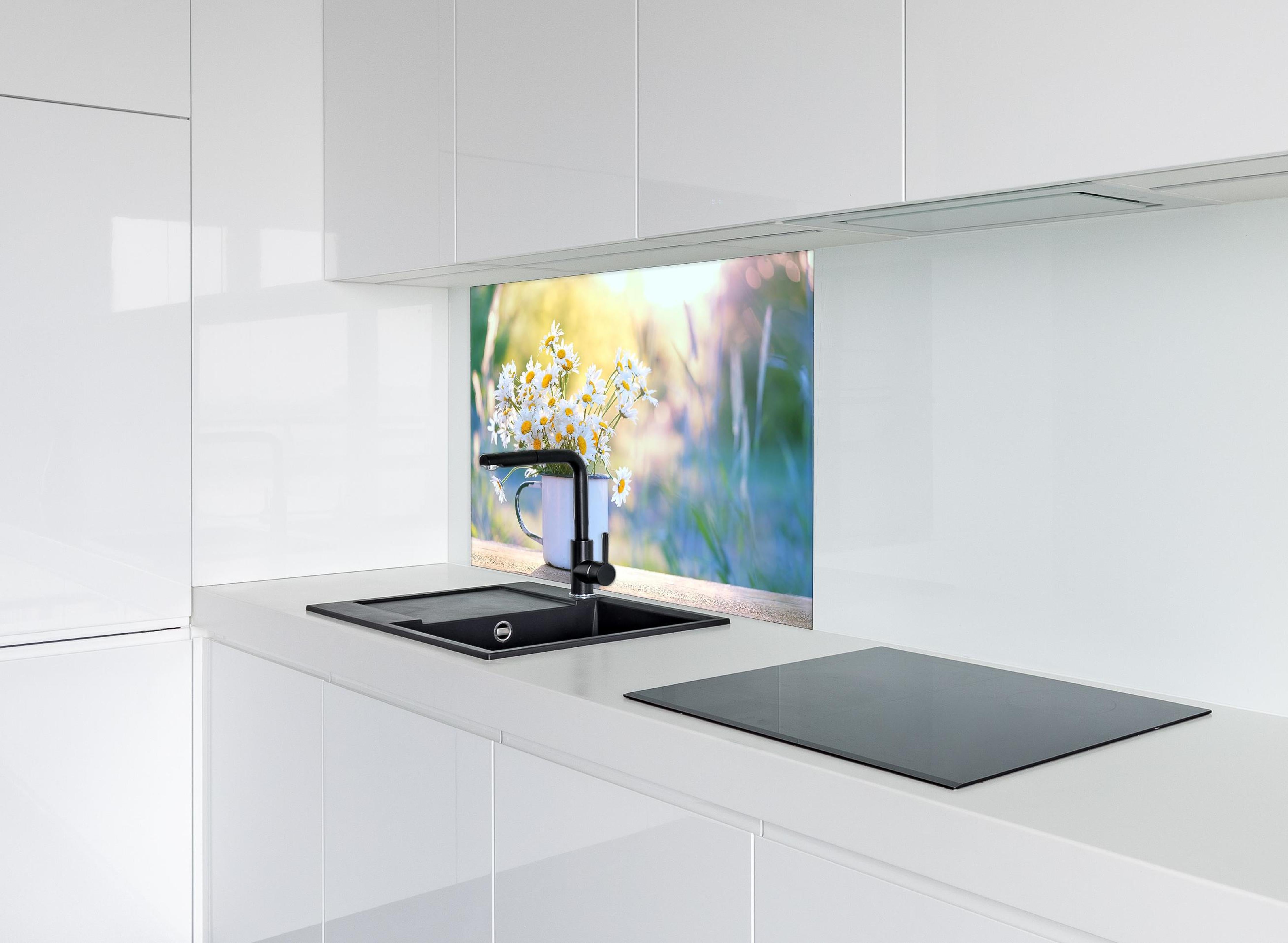 Spritzschutz - Gänseblümchen im Licht des Sonnenuntergangs hinter einem Cerankochfeld zwischen Holz-Kochutensilien