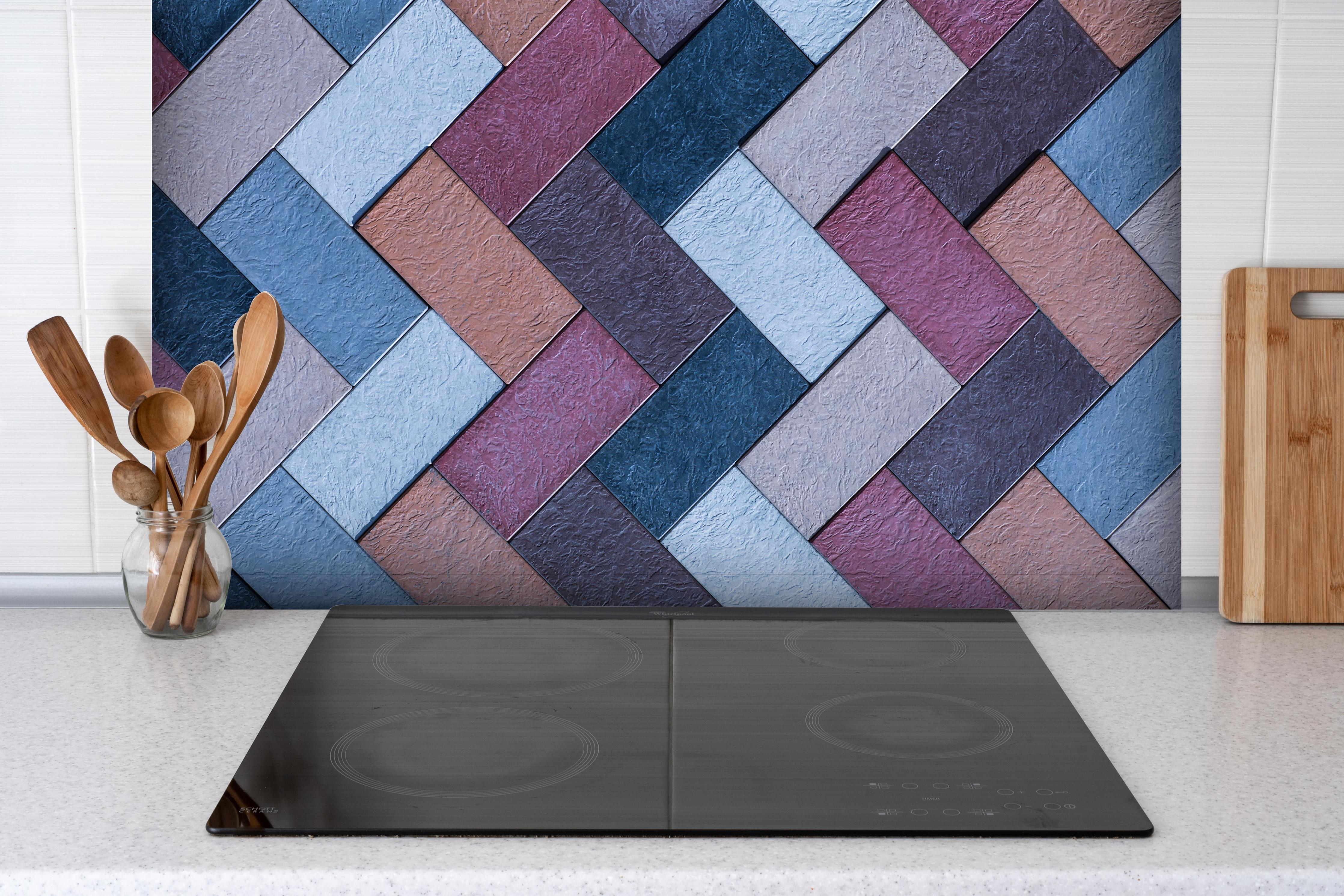 Spritzschutz - Geflochtene Leder-Textur in bunten Farbtönen hinter einem Cerankochfeld zwischen Holz-Kochutensilien