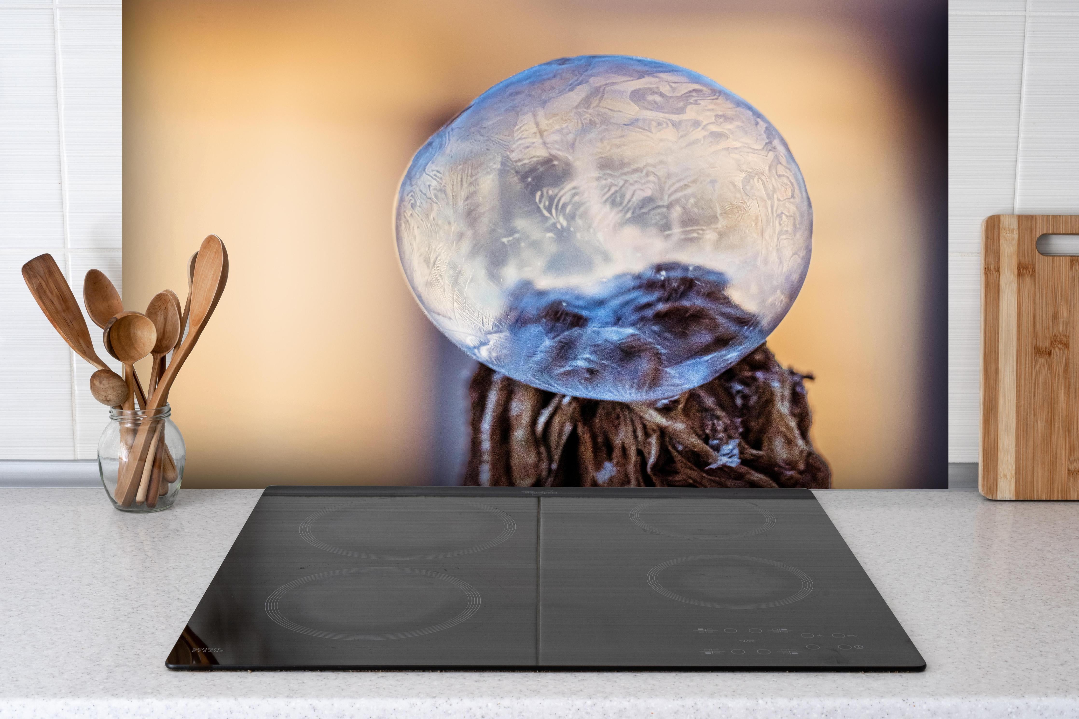 Spritzschutz - Gefrorene Blase Illustration hinter einem Cerankochfeld zwischen Holz-Kochutensilien