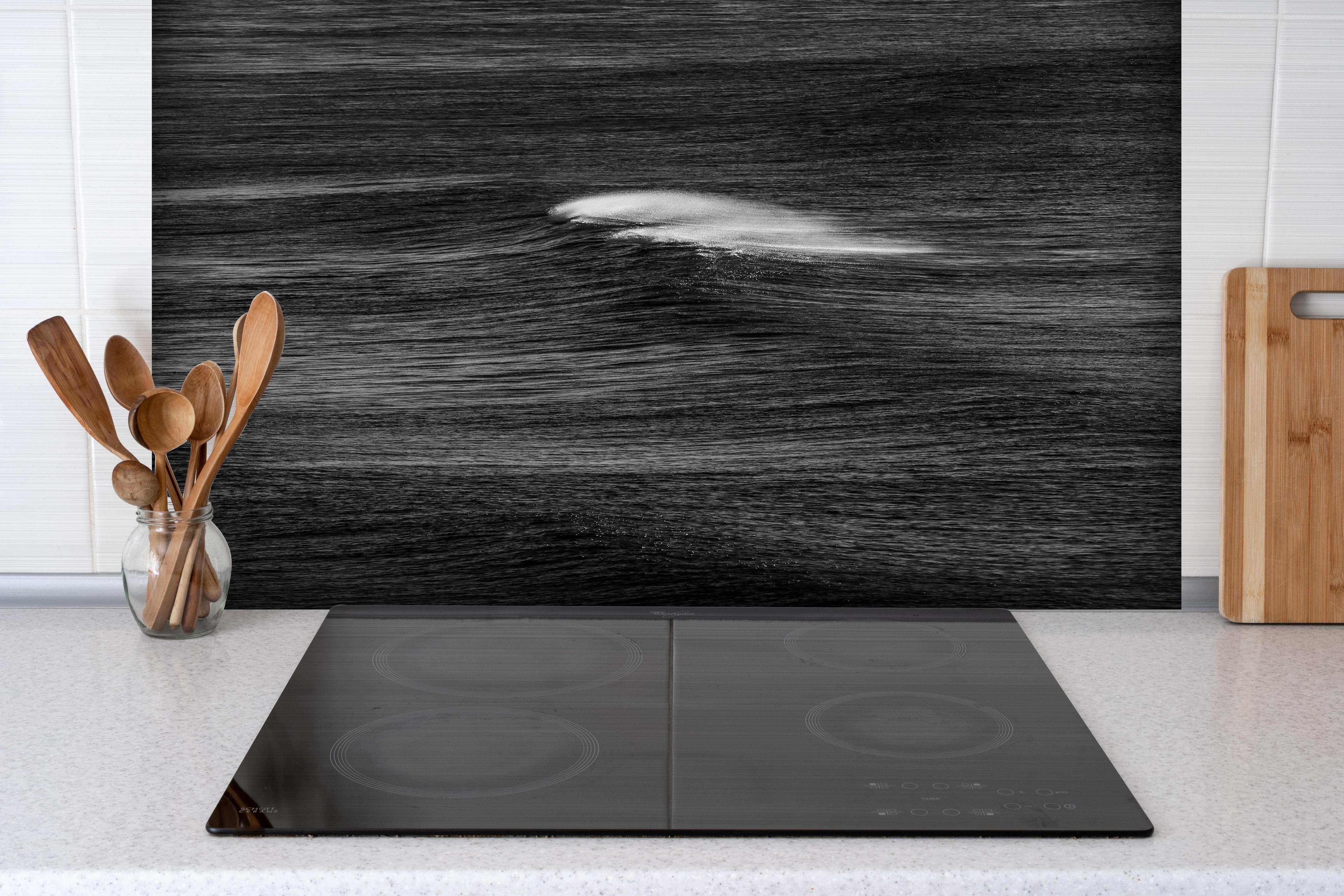 Spritzschutz - Geheimnisvolle Ozeanwellen monochrom hinter einem Cerankochfeld zwischen Holz-Kochutensilien