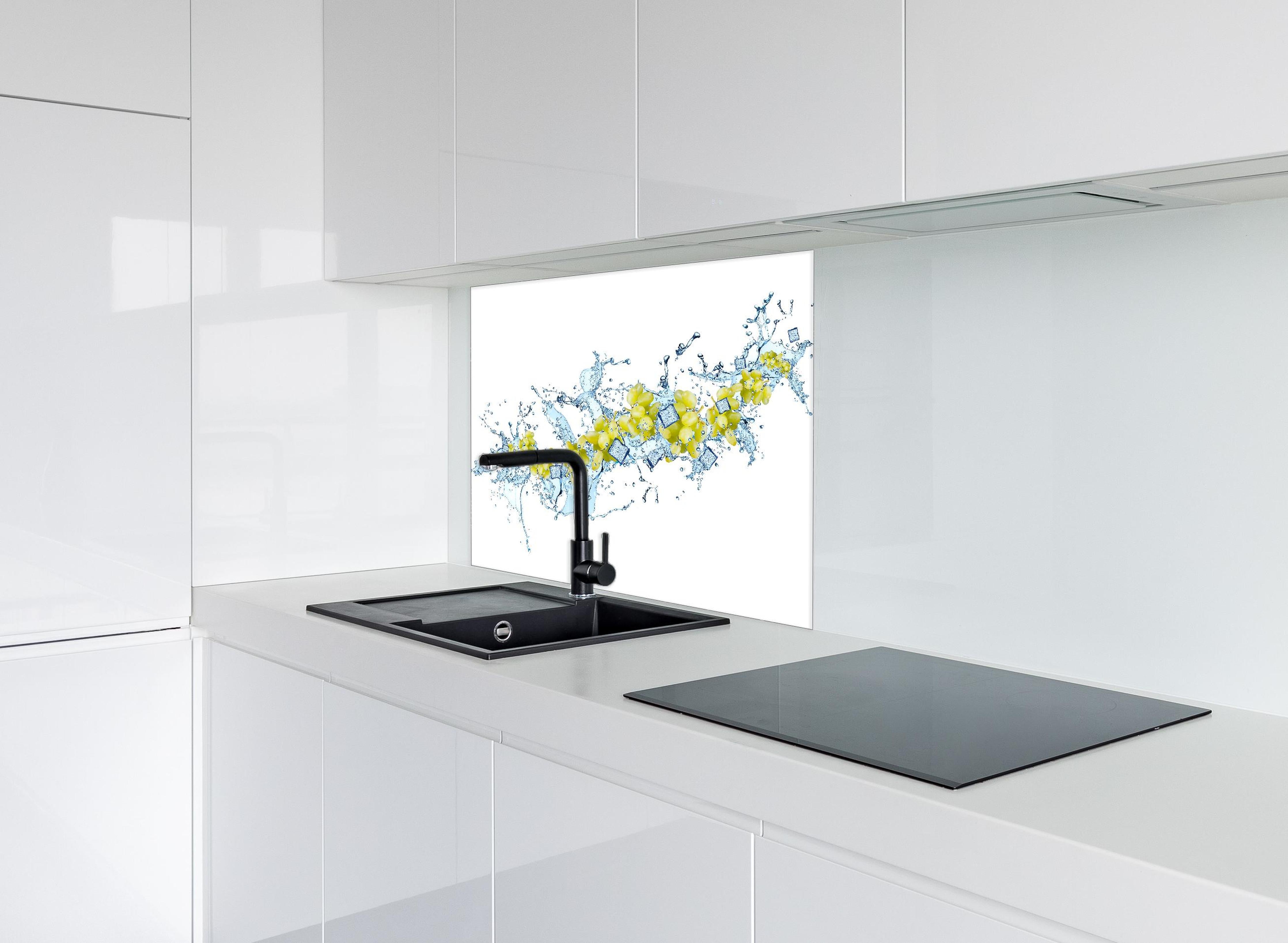 Spritzschutz - Gelbe Trauben mit dynamischem Wasser Splash hinter einem Cerankochfeld zwischen Holz-Kochutensilien