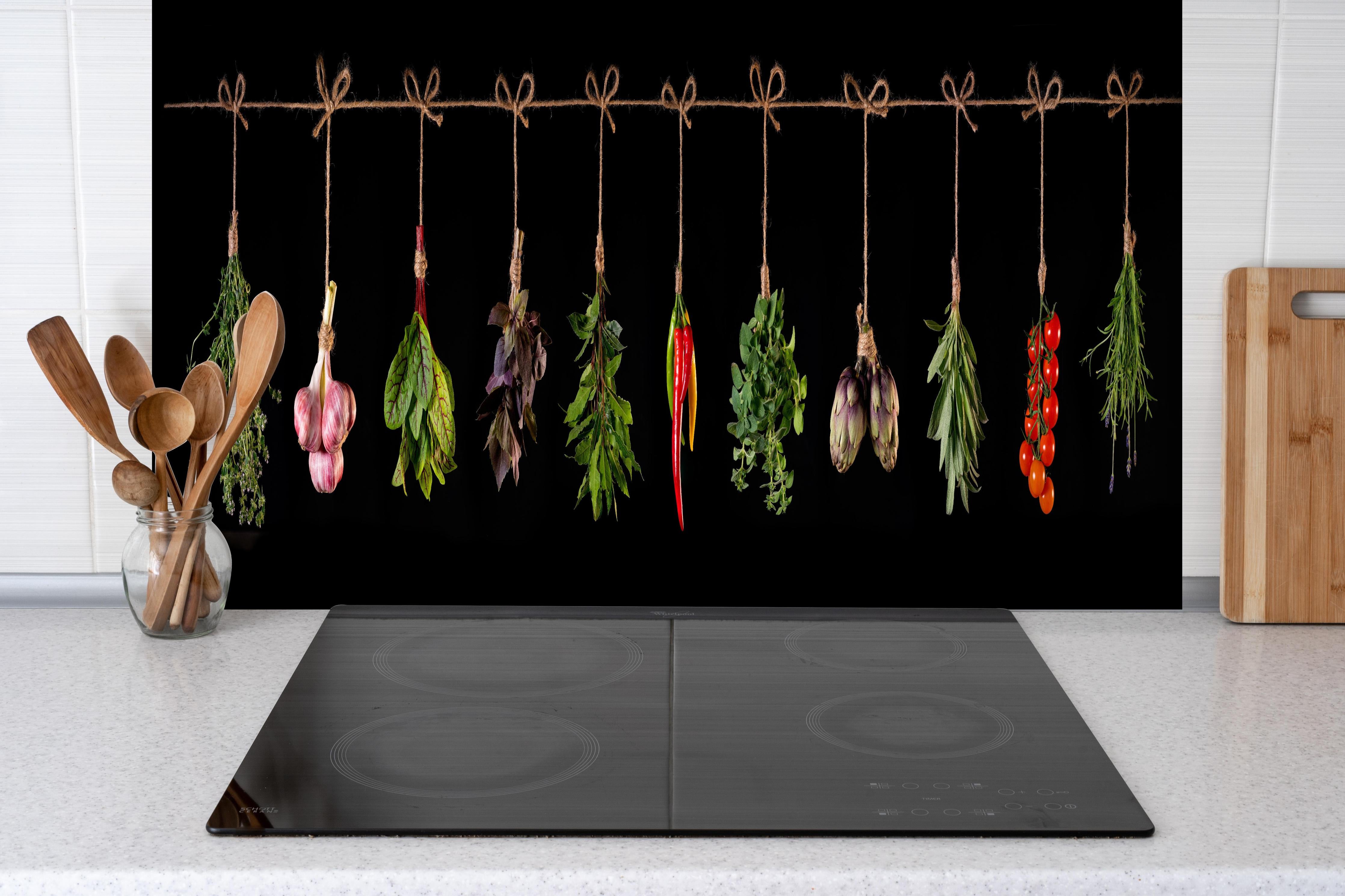 Spritzschutz - Gemüse & Kräuter aufgehängt hinter einem Cerankochfeld zwischen Holz-Kochutensilien