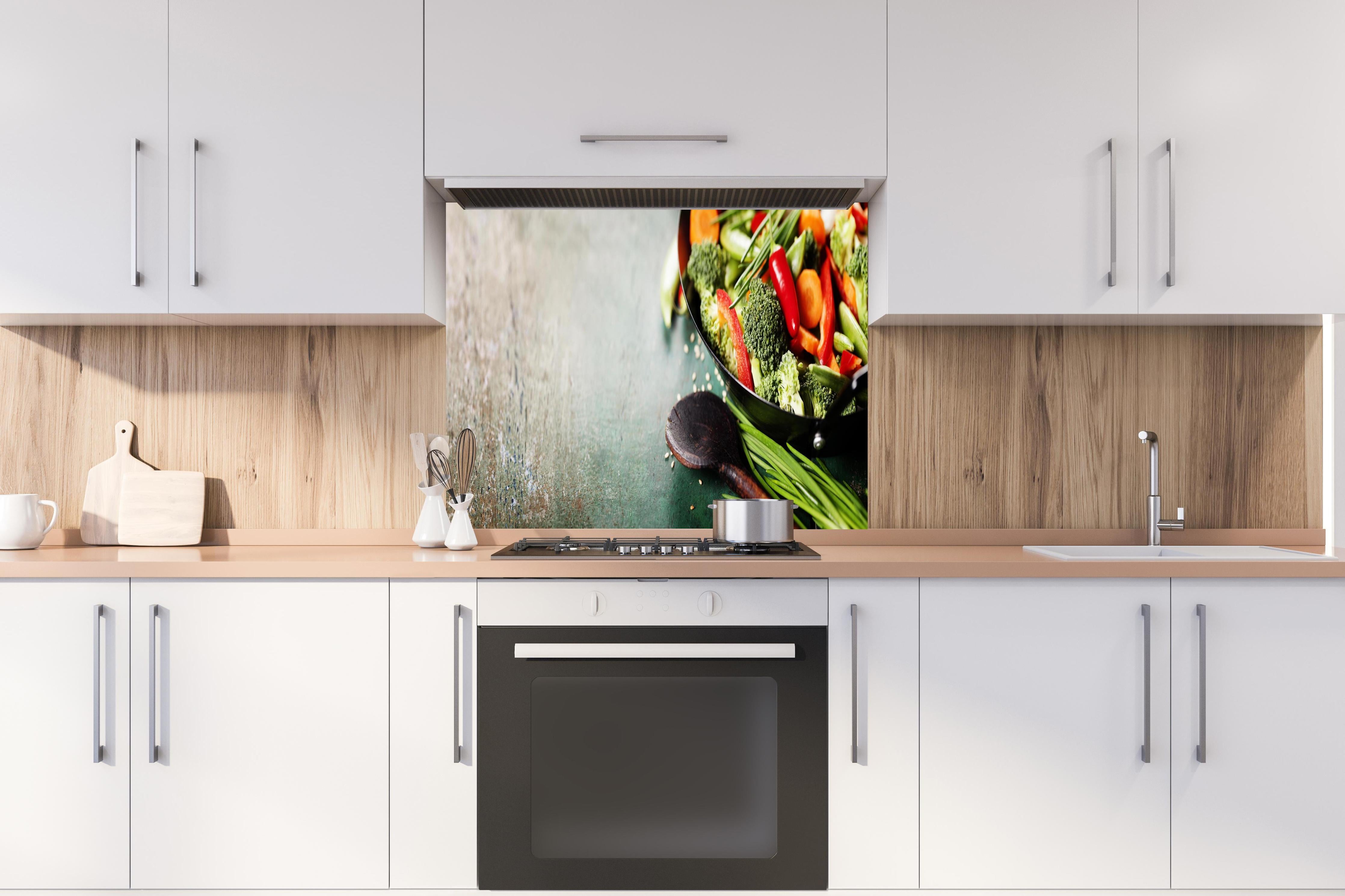 Spritzschutz - Gemüse kochen im Wok hinter einem Cerankochfeld zwischen Holz-Kochutensilien