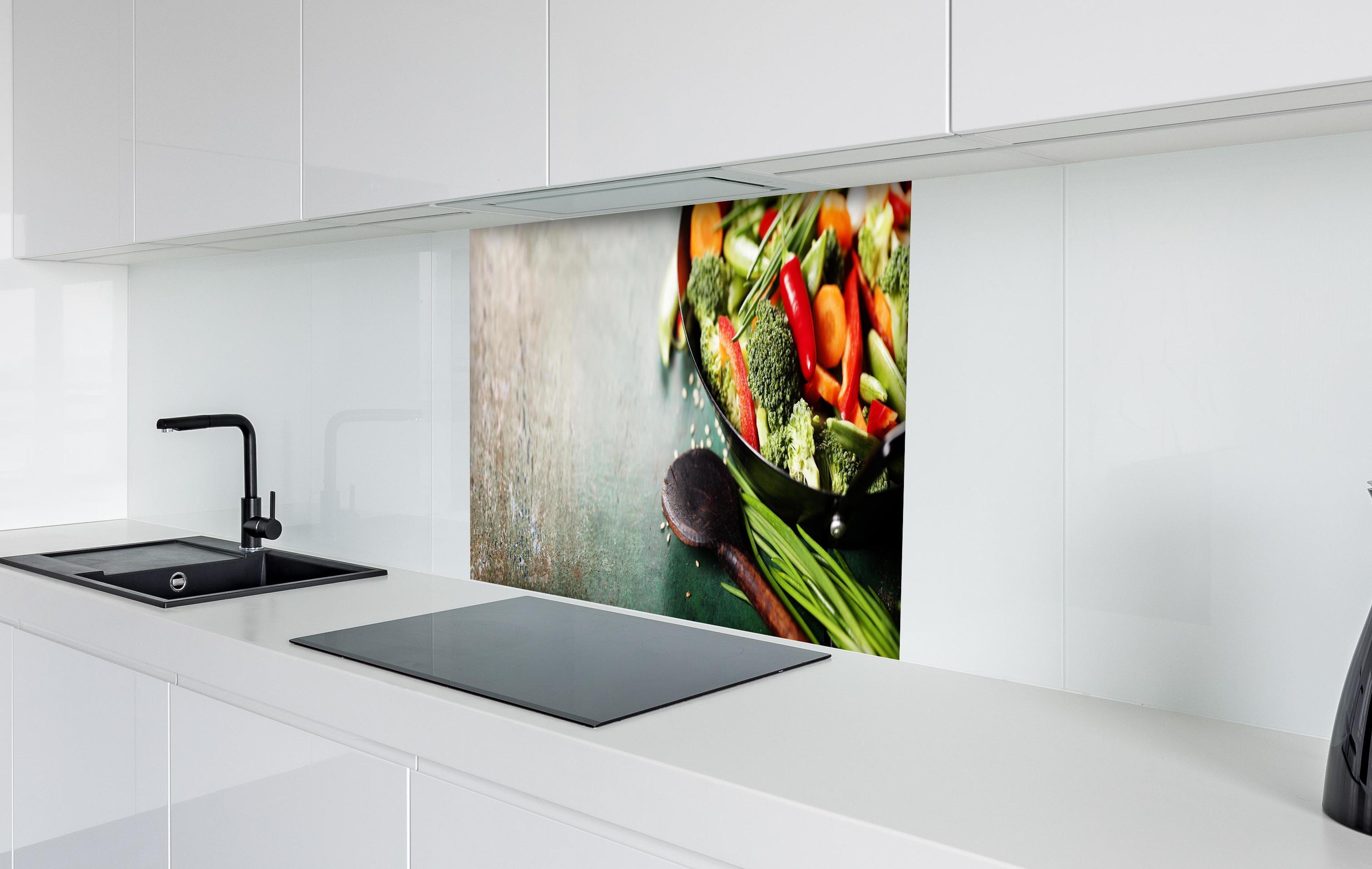 Spritzschutz - Gemüse kochen im Wok hinter einem Cerankochfeld zwischen Holz-Kochutensilien