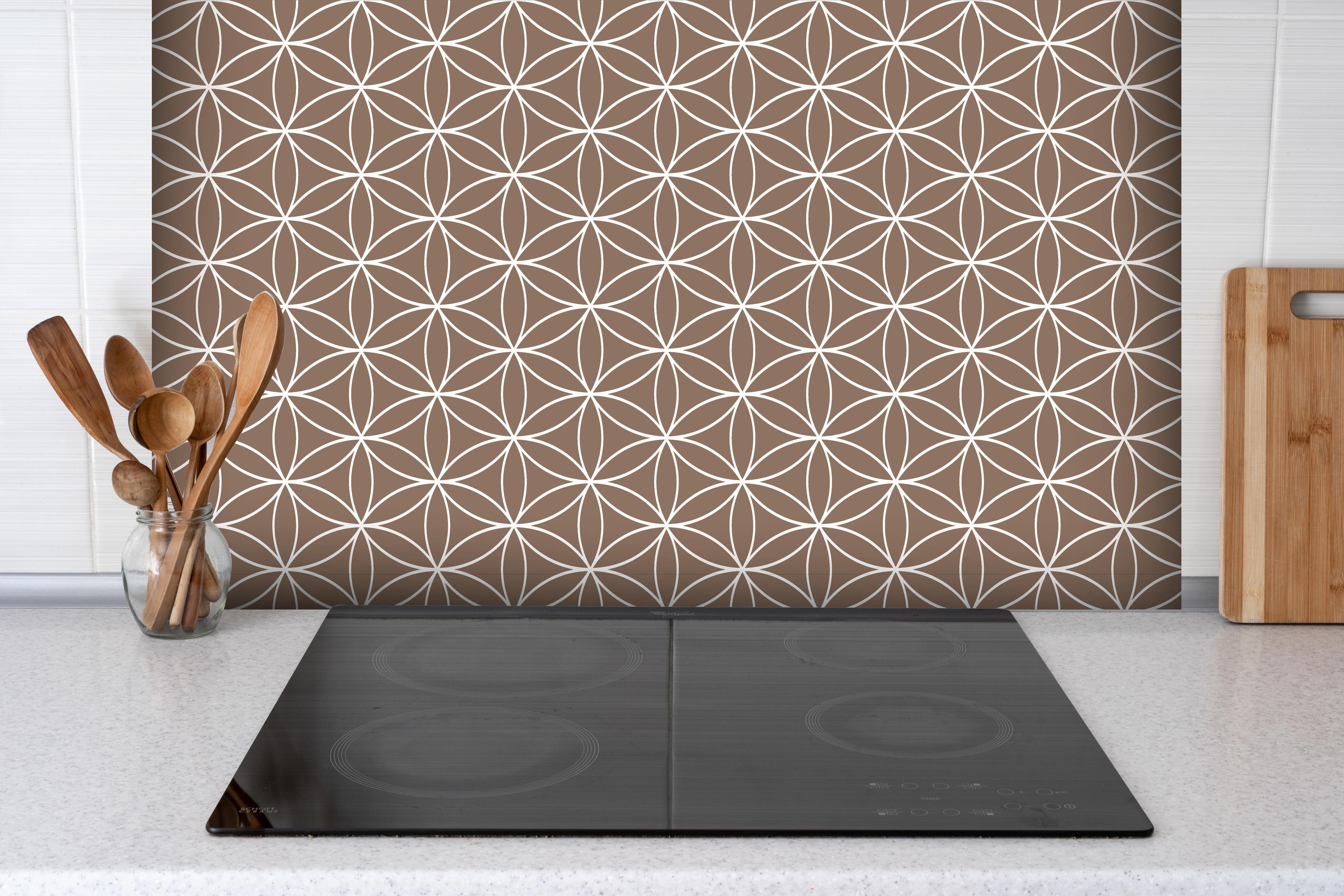 Spritzschutz - Geometrica Fiori Sigaro hinter einem Cerankochfeld zwischen Holz-Kochutensilien