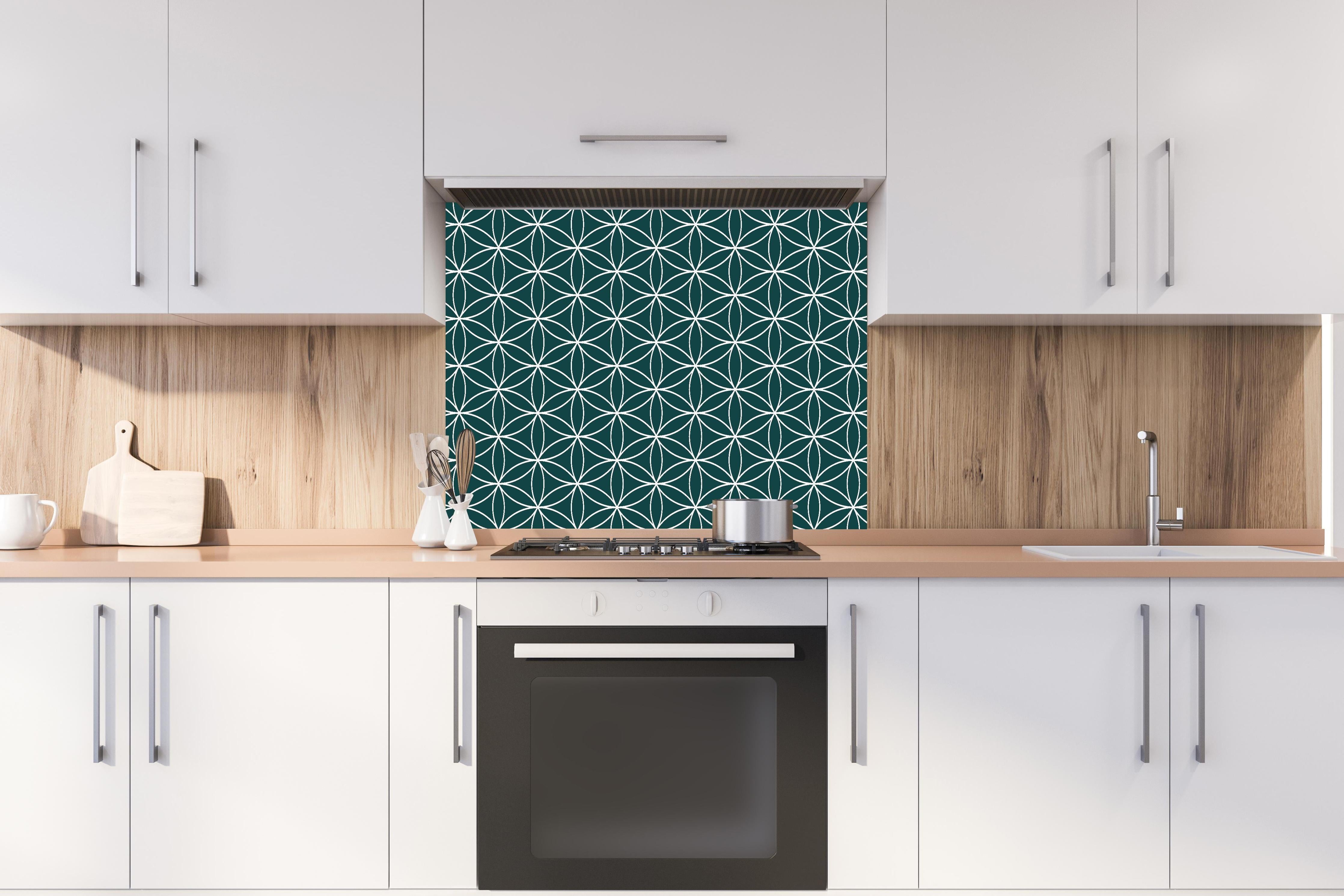 Spritzschutz - Geometrica Fiori Verde petrolio hinter einem Cerankochfeld zwischen Holz-Kochutensilien