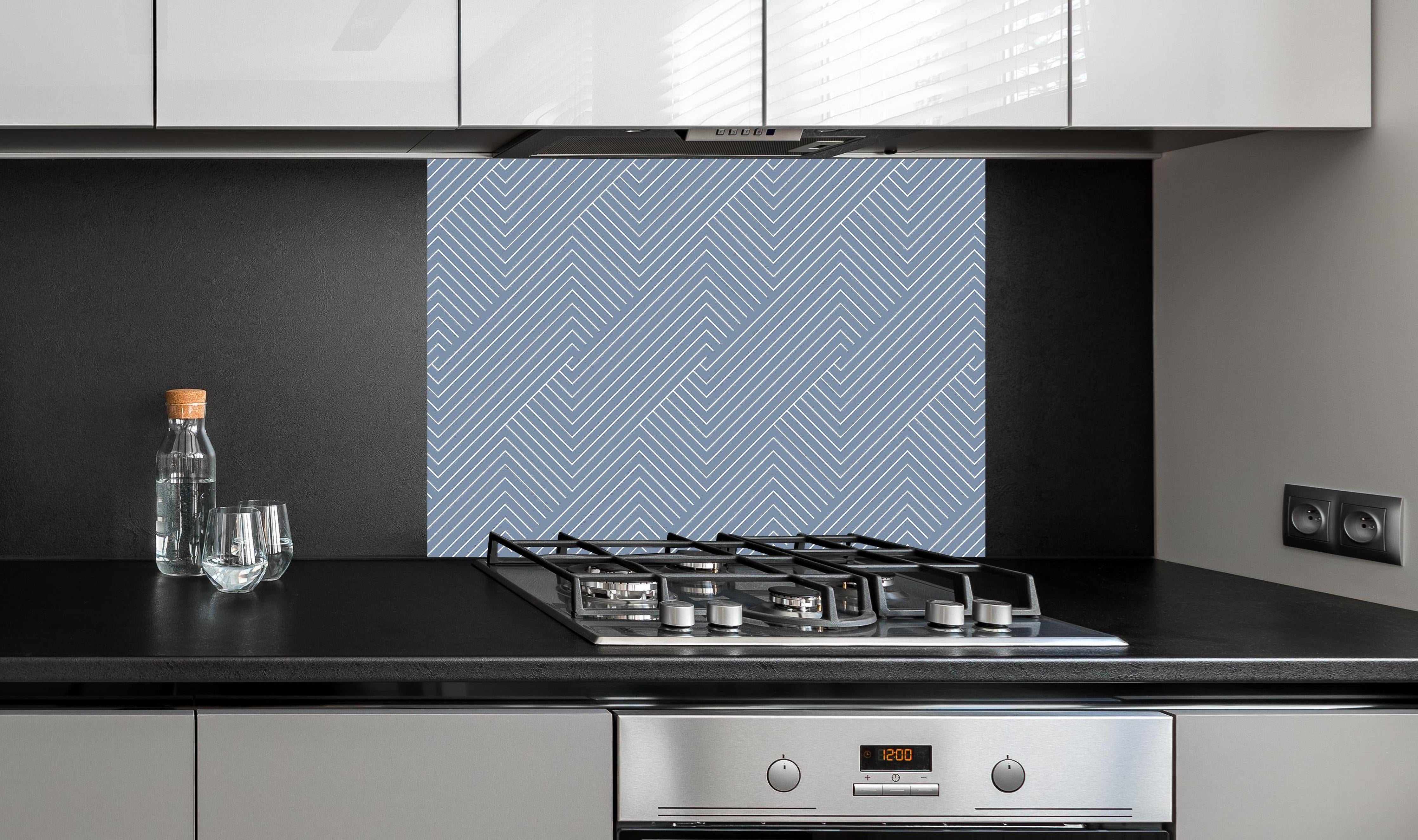 Spritzschutz - Geometrica Intreccio Azzurro polvere hinter einem Cerankochfeld zwischen Holz-Kochutensilien